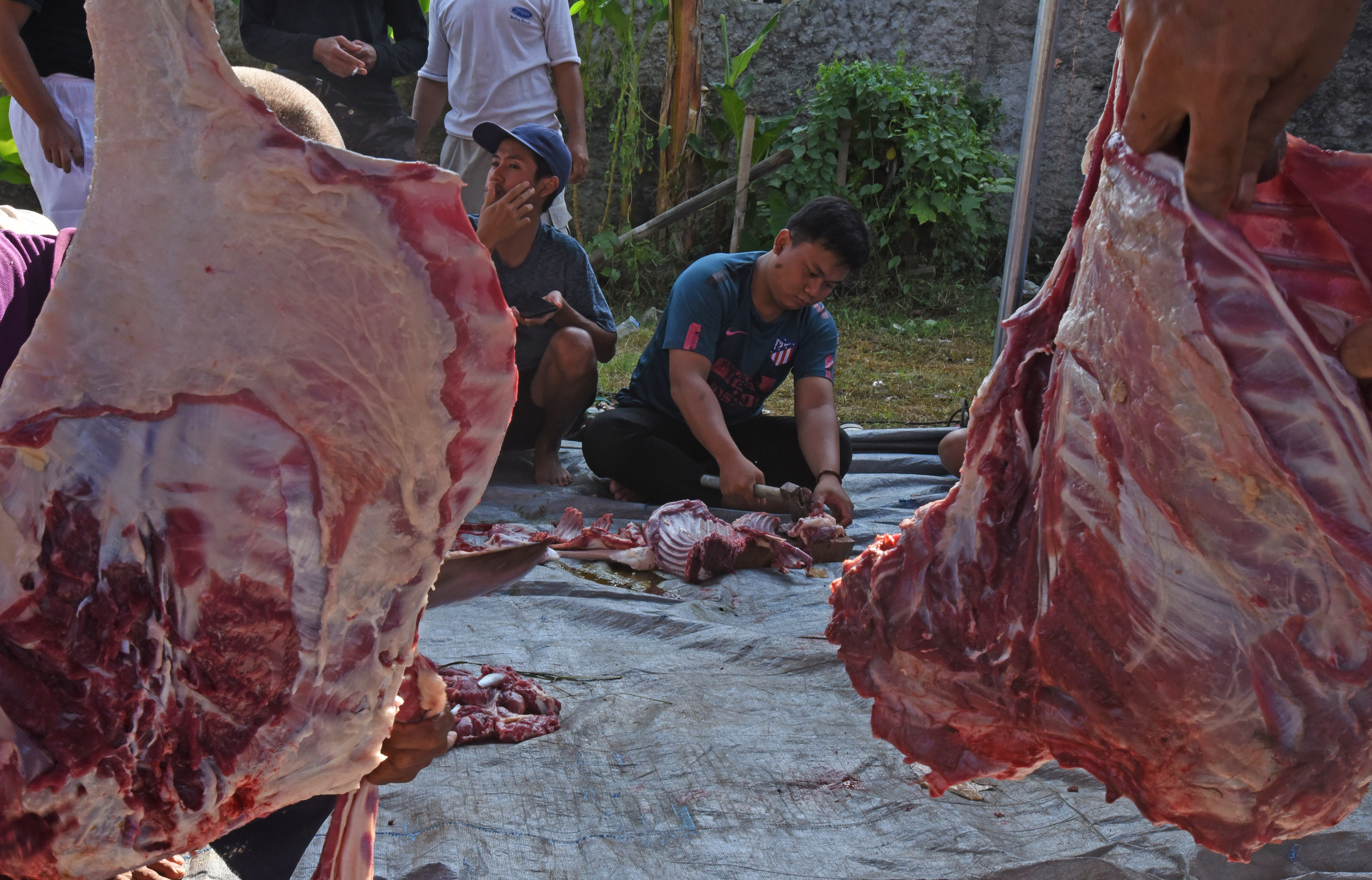 Warga mengiris daging hewan kurban untuk dibagikan di Kompleks Perumahan Makmur Jaya 3, di Serang, Banten, Minggu (10/7/2022).