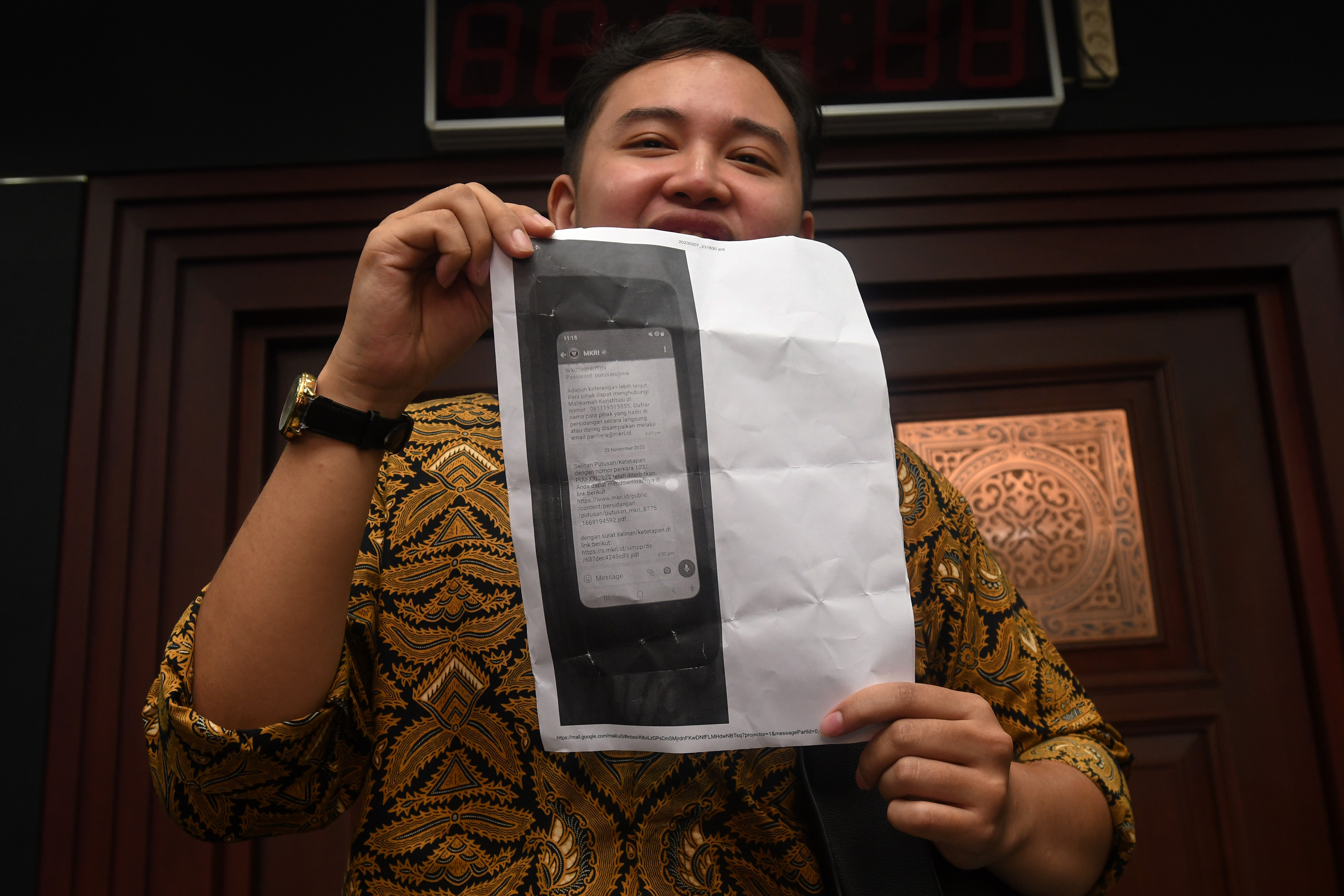 Pengacara Zico Leonard Djagardo Simanjuntak menunjukkan kertas berisi foto bukti kasus dugaan pengubahan substansi putusan MK