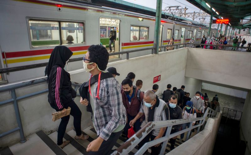 Calon penumpang berjalan menuju rangkaian kereta rel listrik (KRL) di Stasiun Manggarai, Jakarta.