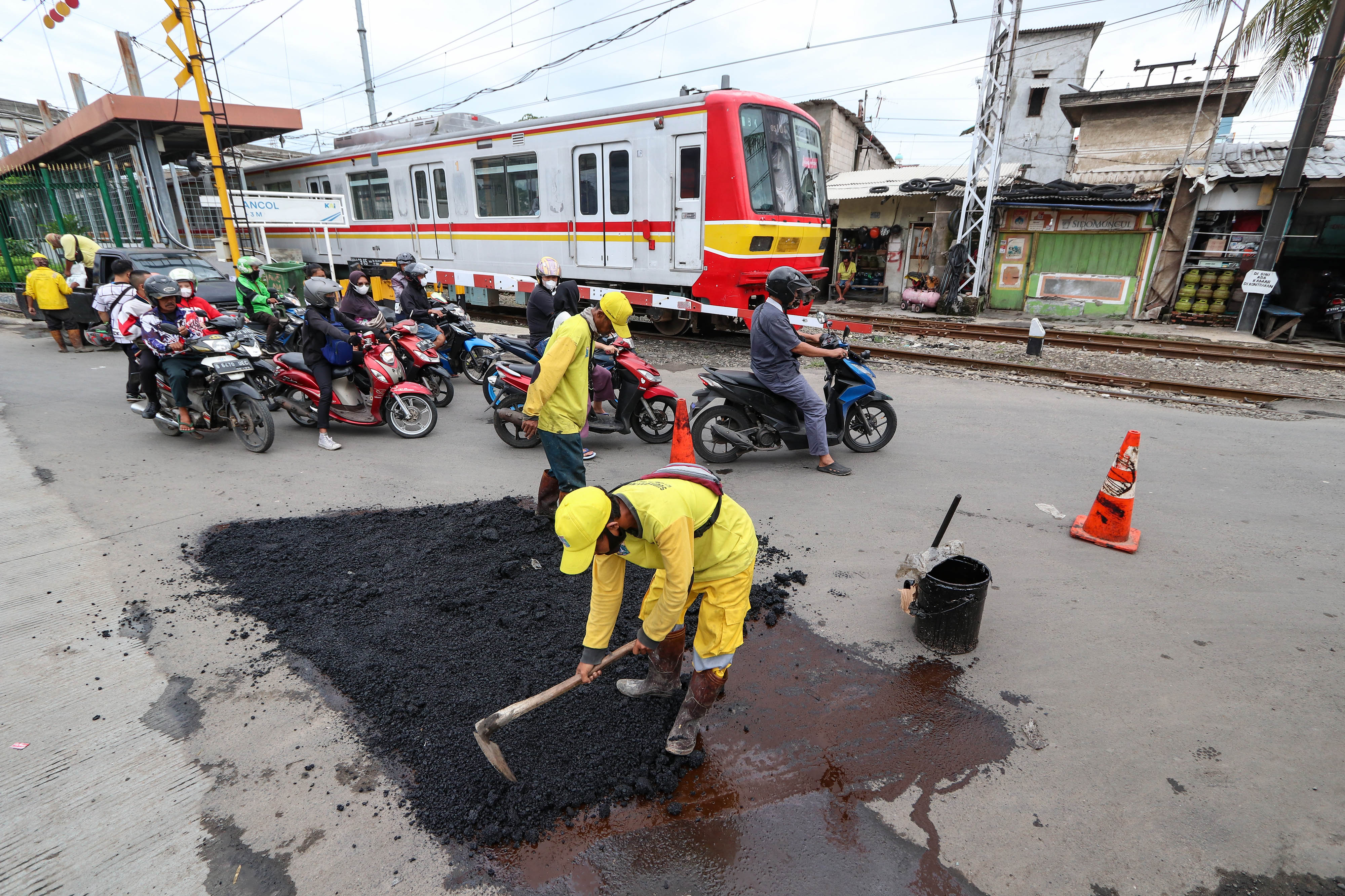 Petugas dari Suku Dinas Bina Marga Jakarta Utara mengaspal jalan di Pademangan, Jakarta, Kamis (9/2/2023).