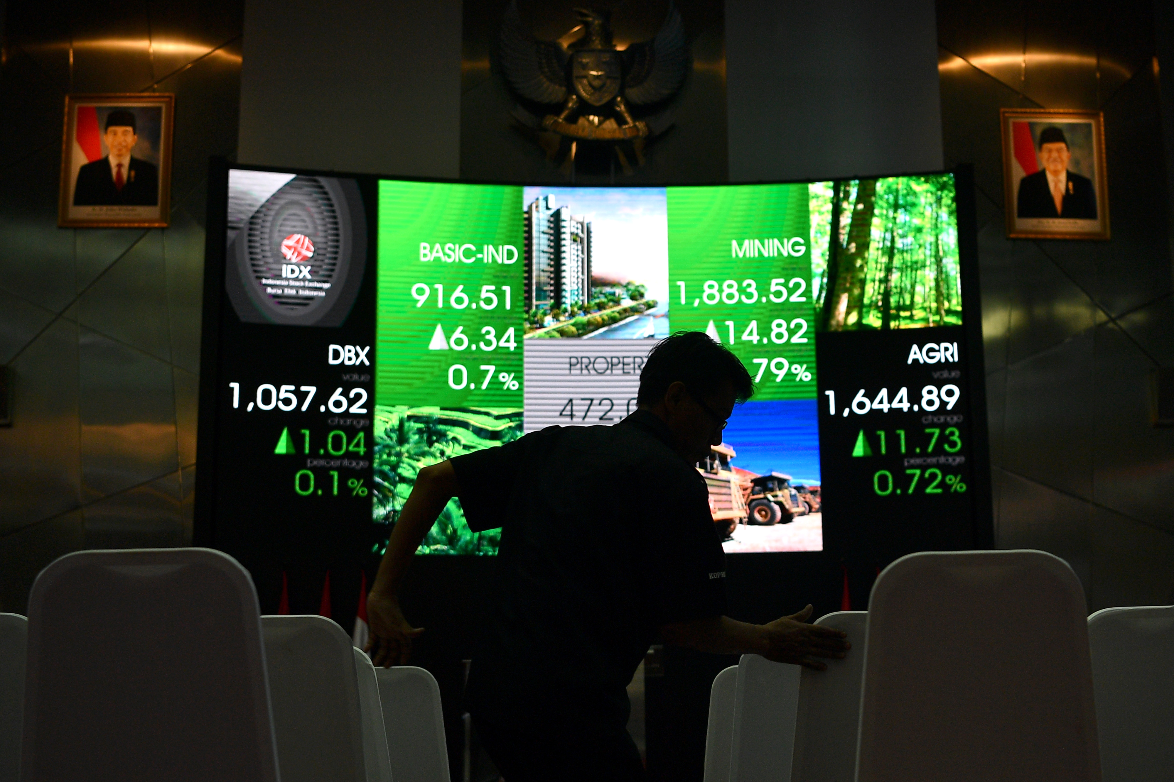 Karyawan menata kursi di depan monitor pergerakan Indeks Harga Saham Gabungan (IHSG) di Bursa Efek Indonesia, Jakarta, Jumat (25/1/2019).