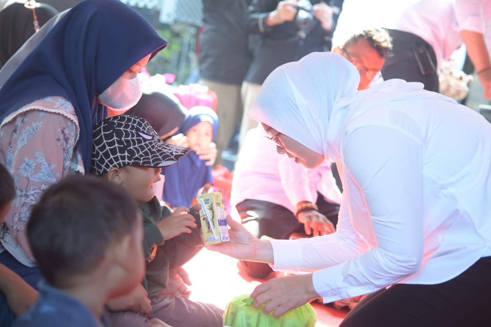 Bupati Purwakarta Anne Ratna Mustika (kanan) memberikan susu kepada seorang anak.