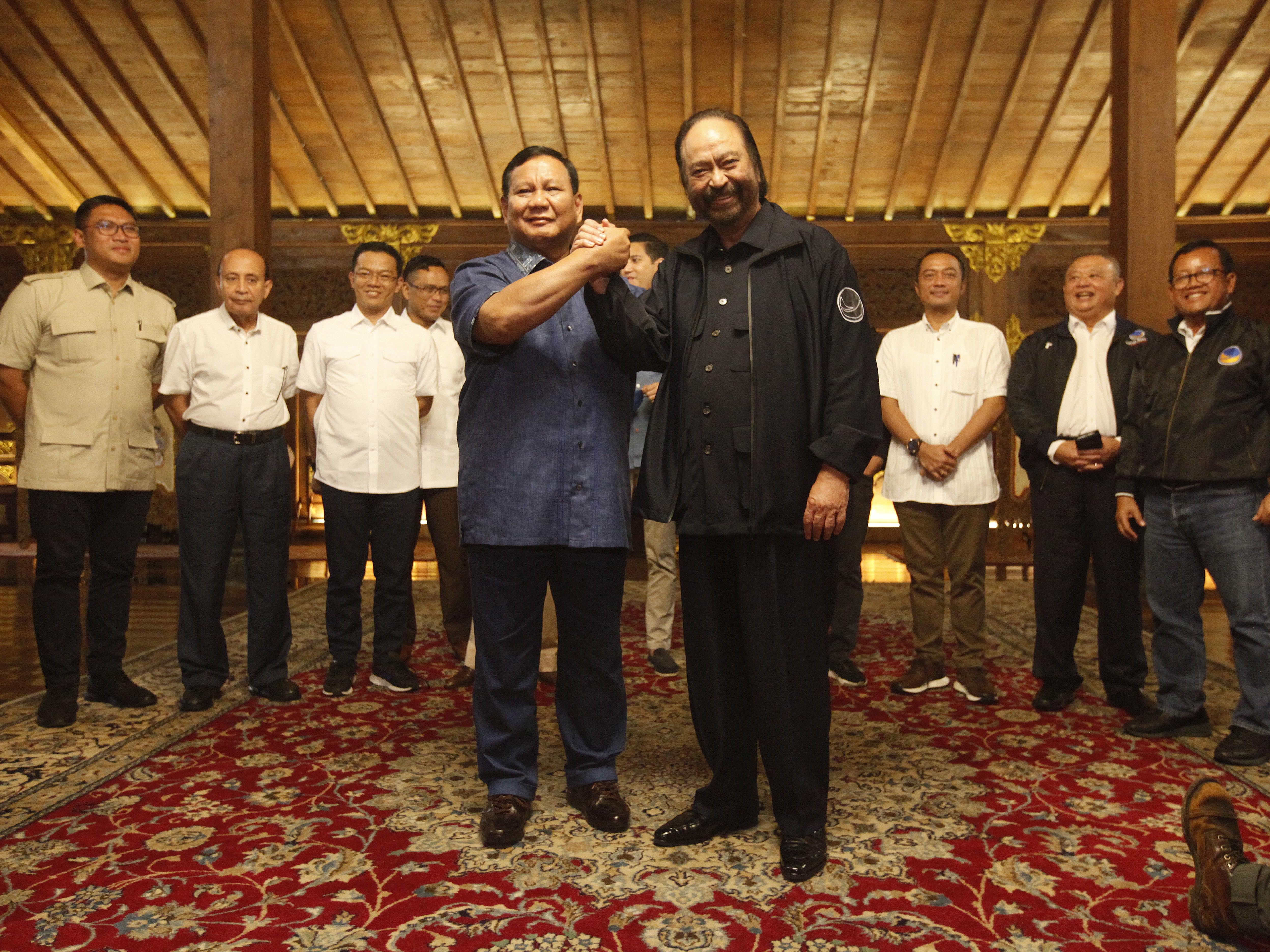 Ketua Umum Partai NasDem Surya Paloh bersama Ketua Umum Partai Gerindra Prabowo Subianto berjabat tangan usai berbicara kepada wartawan.