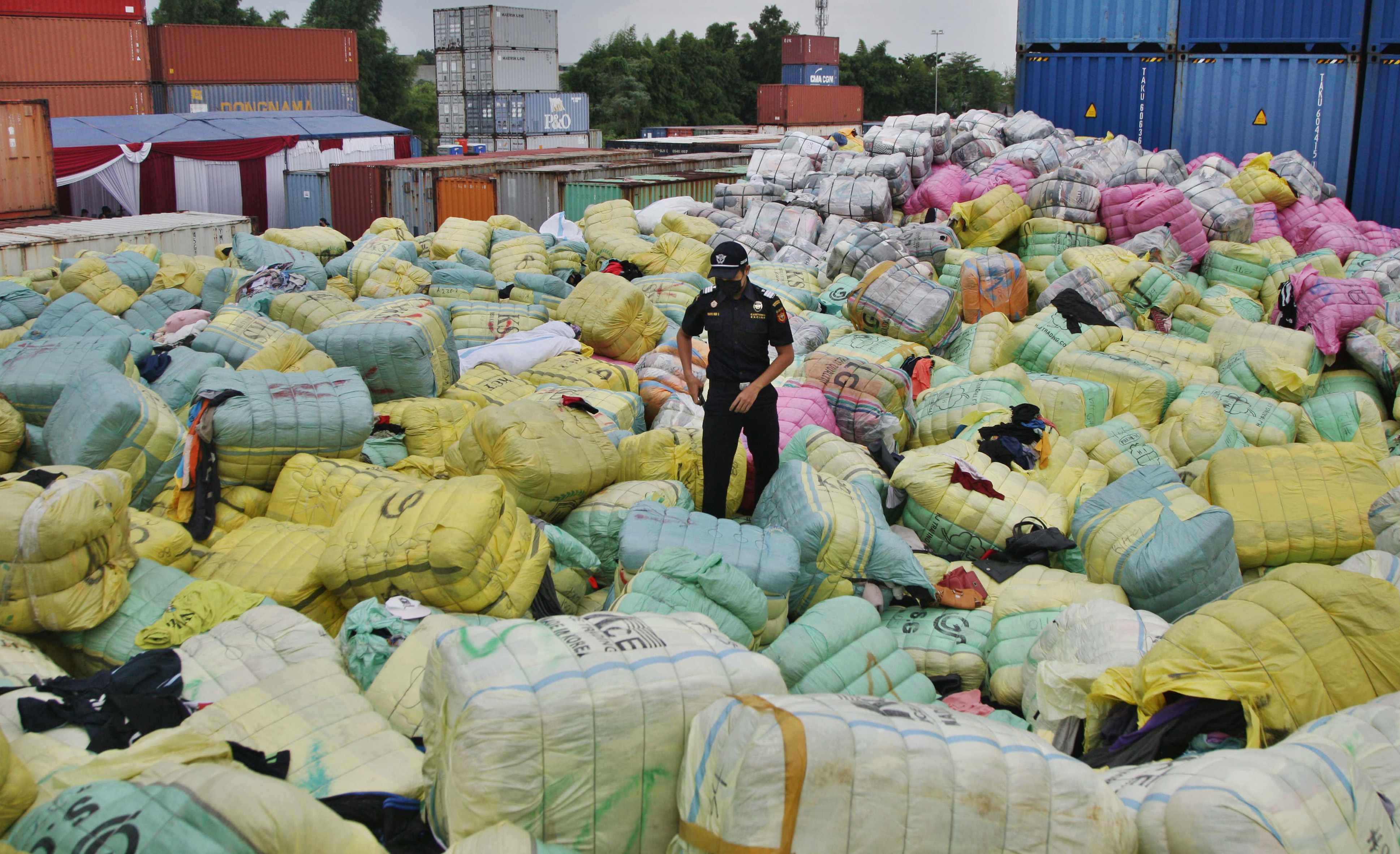 Petugas Bea Cukai memeriksa tumpukan ribuan bal pakaian bekas impor di Bekasi, Selasa (28/03)