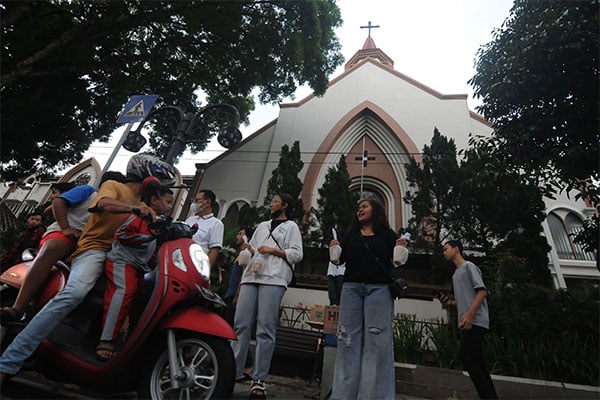 Anggota Orang Muda Katolik (OMK) Gereja Katolik Santo Paulus Miki membagikan takjil kepada pengendara motor di Salatiga