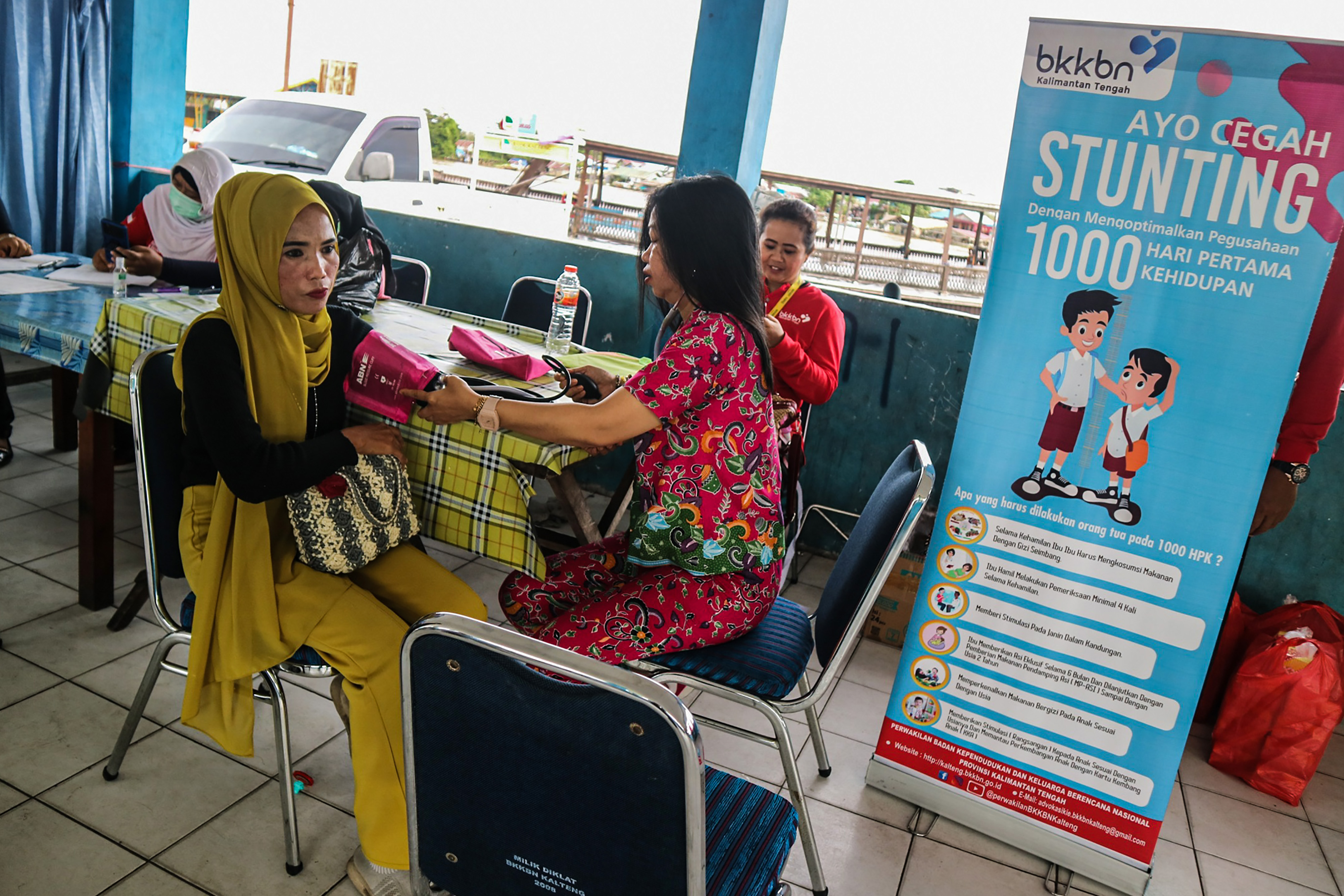 Petugas kesehatan memeriksa tekanan darah (tensi) kepada warga saat giat pelayanan KB gratis di Pelabuhan Rambang, Palangka Raya, Kalimantan
