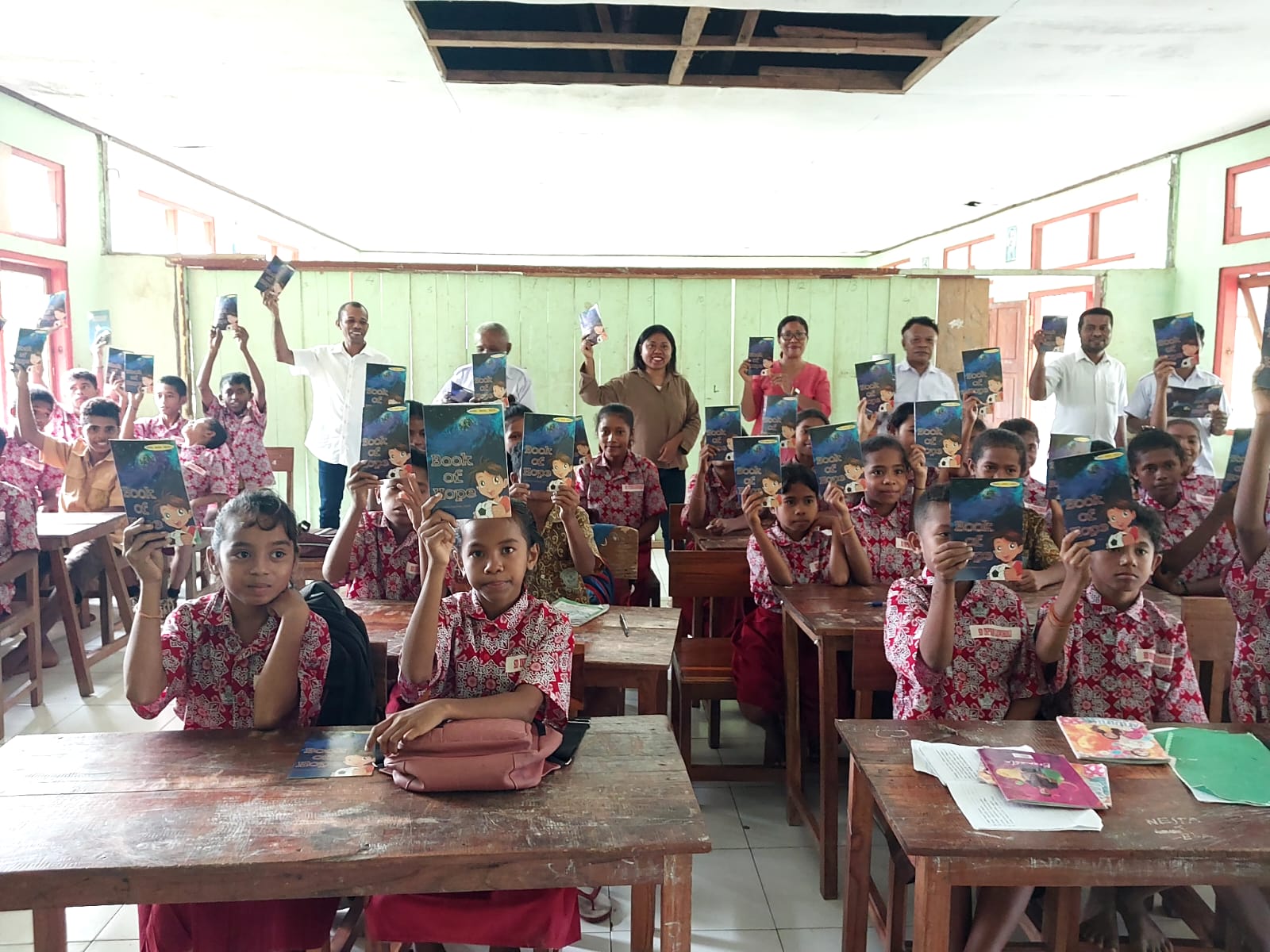 Siswa dan guru pose bersama usai menerima buku bantuan dari Komunitas dan Taman Baca Mawar Merona