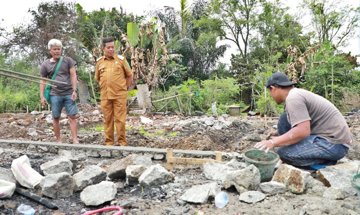 Bupati Simalungun, Sumatra Utara, Radiapoh Hasiholan Sinaga melihat warga yang tengah membangun kembali rumah mereka setelah terbakar. 