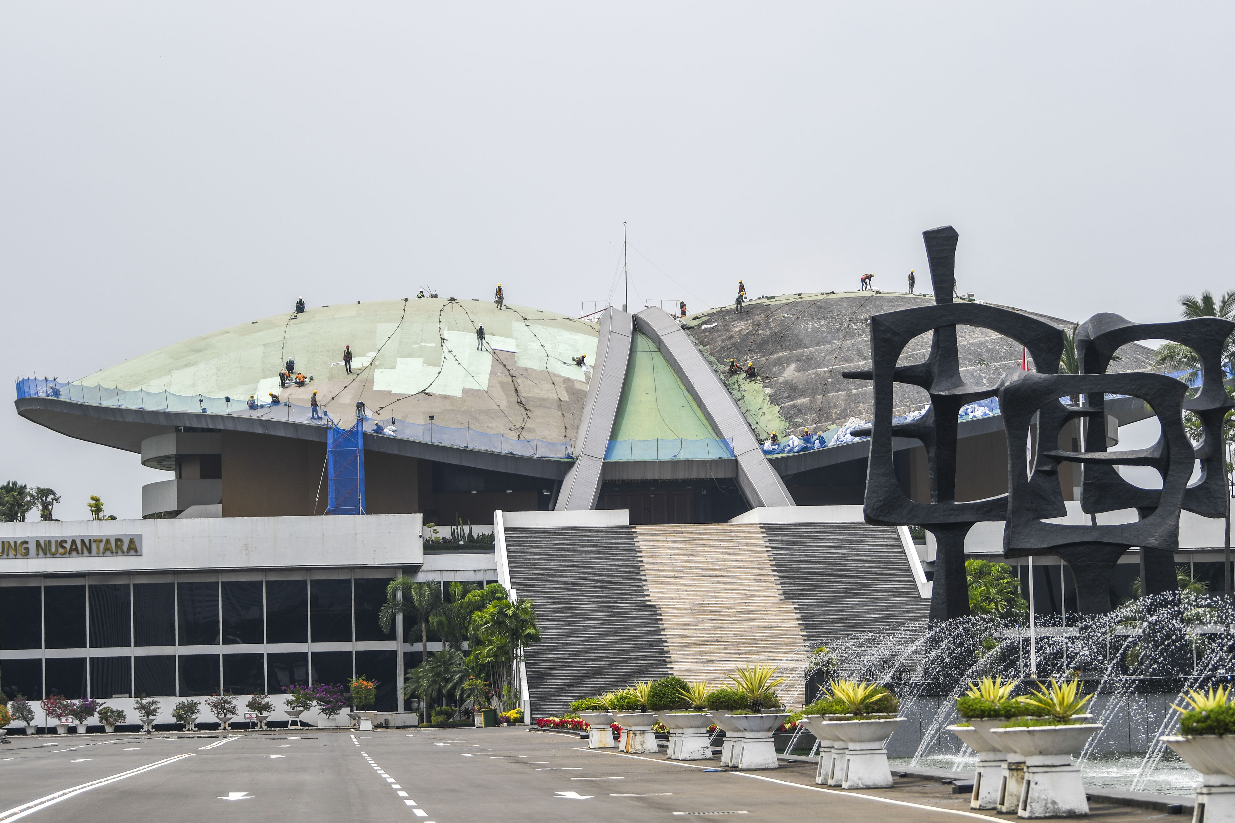 Pekerja menyelesaikan renovasi pengecatan dome atau atap Gedung Nusantara DPR di kompleks Parlemen