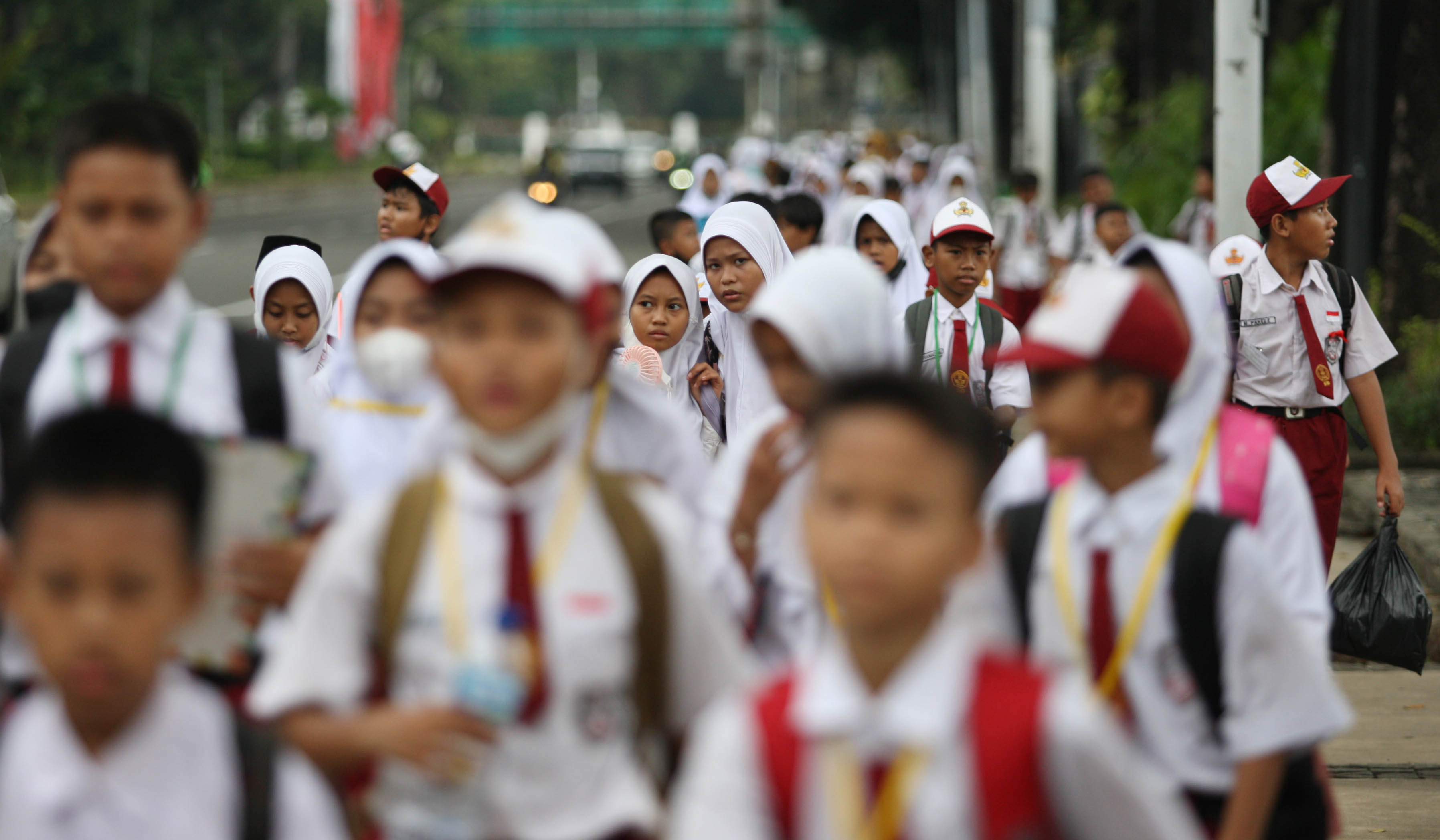 Para murid SDN 05 Petukangan Jakarta mengikuti kegiatan belajar mengajar di luar ruang kelas.