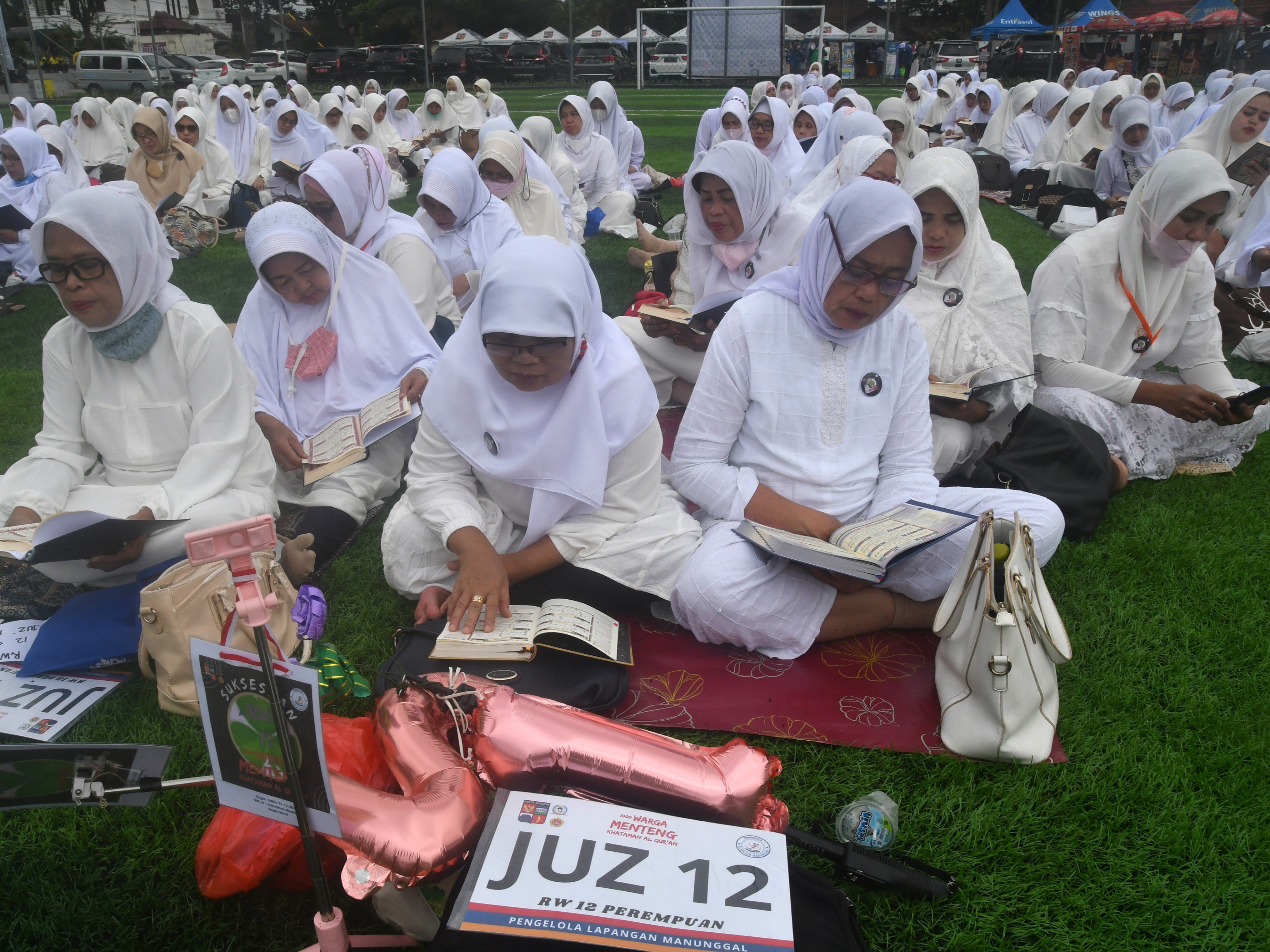 Sejumlah warga membaca Al-Qur'an secara bersama-sama di lapangan Sepak Bola Mini, Taman Manunggal, Kota Bogor, Jawa Barat.