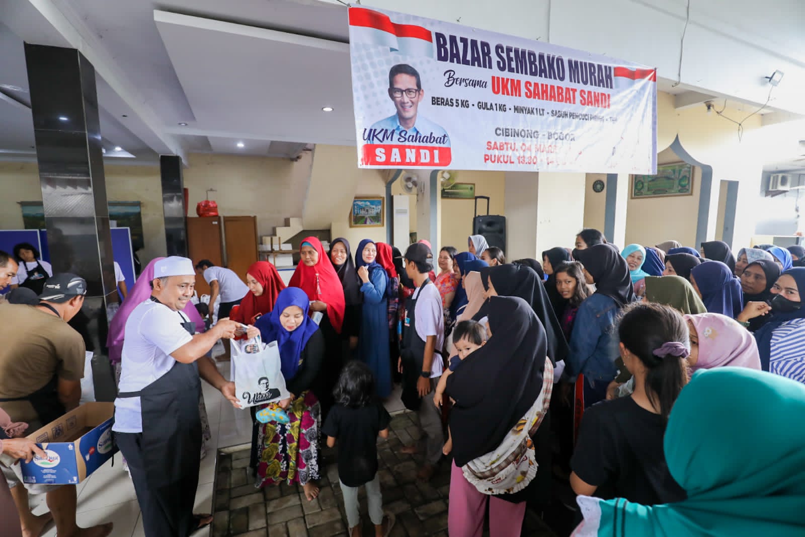 Ratusan warga Cibinong, Kabupaten Bogor mengantre bazar sembako murah yang digelar UKM Sahabat Sandi Uno, Minggu (5/3/2023)