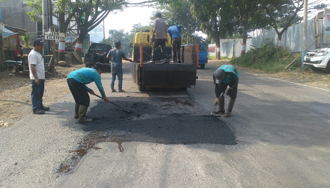 Pekerja sedang menambal kondisi infrastruktur jalan yang rusak di jalur alternatif di Kabupaten Cianjur, Jabar pada mudik 2022.