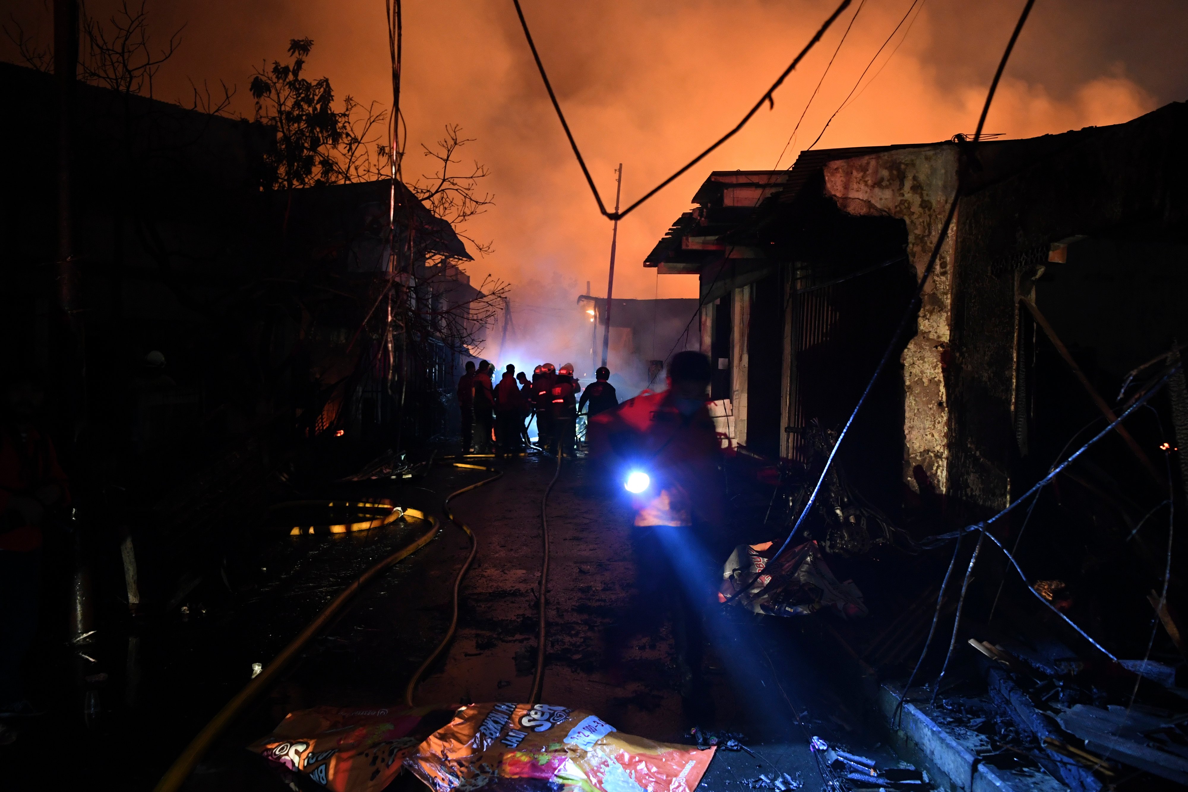 Sejumlah petugas berusaha memadamkan api yang membakar rumah warga imbas kebakaran Depo Pertamina Plumpang