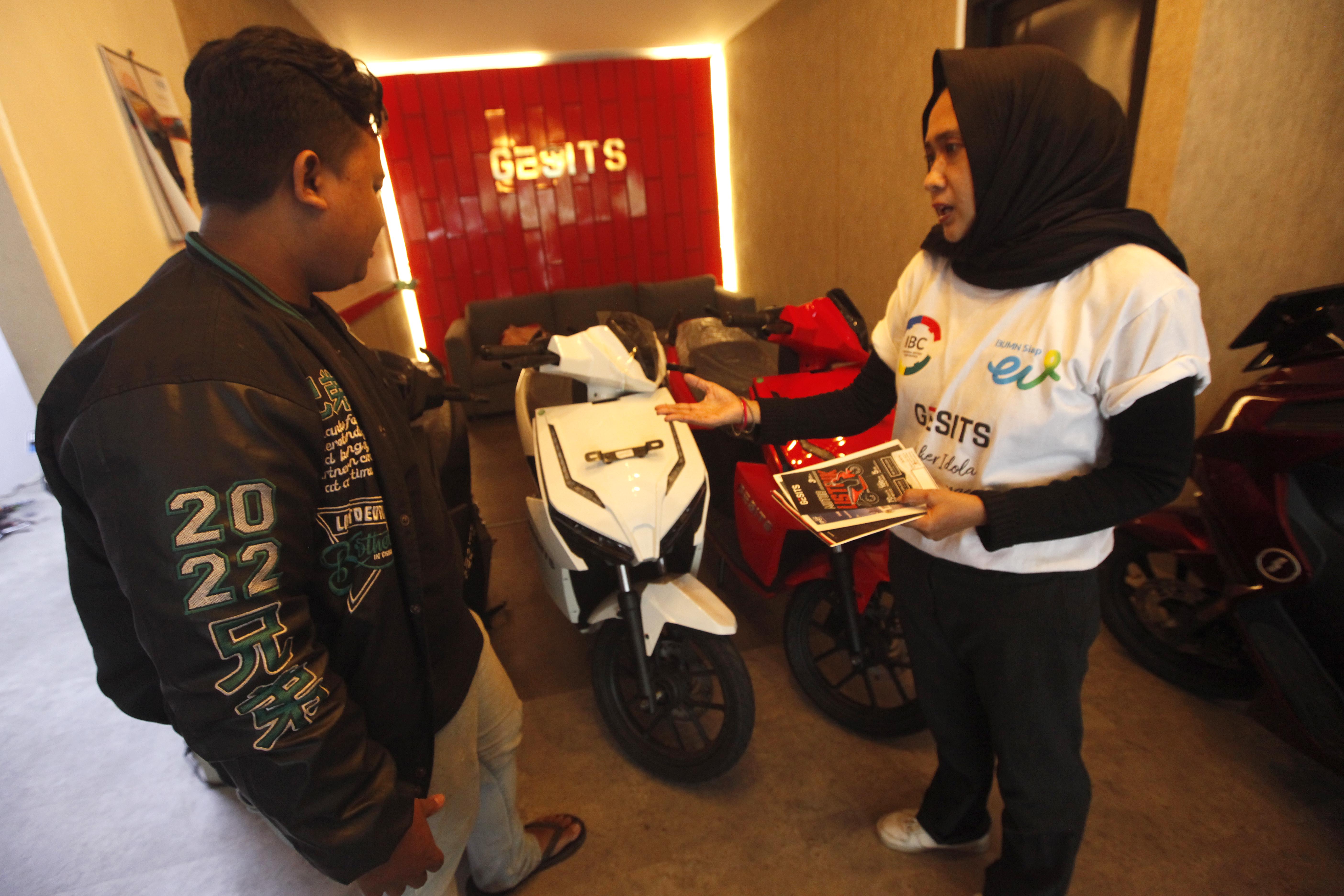  Tenaga penjual memberikan edukasi kepada calon pembeli terkait produk kendaraan listrik di diler motor listrik Gesits di kawasan Bintaro.