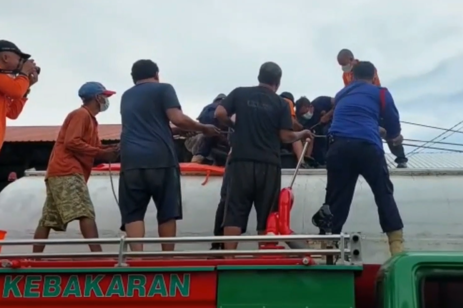Petugas sedang mengevakuasi korban dari dalam tangki truk.