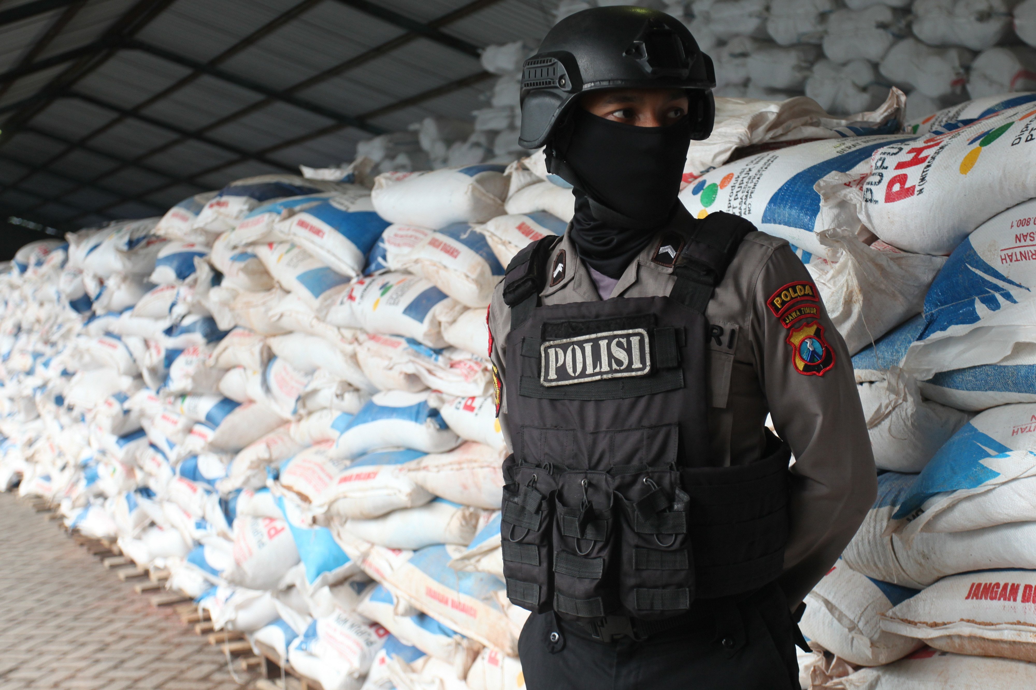 Seorang polisi menjaga pupuk ilegal yang disita Polda Jawa Timur