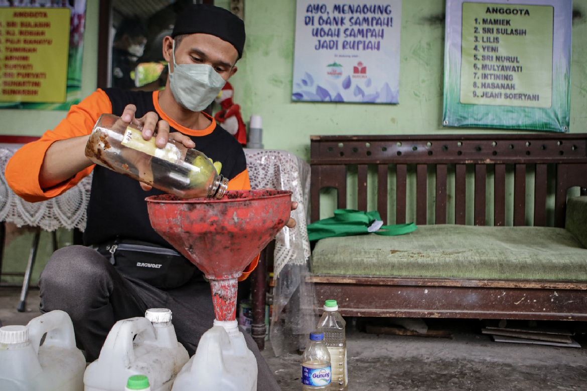 Petugas Dinas Lingkungan Hidup (DLH) memasukkan minyak jelantah hasil sedekah warga ke dalam jeriken di Karawaci, Kota Tangerang, Banten.