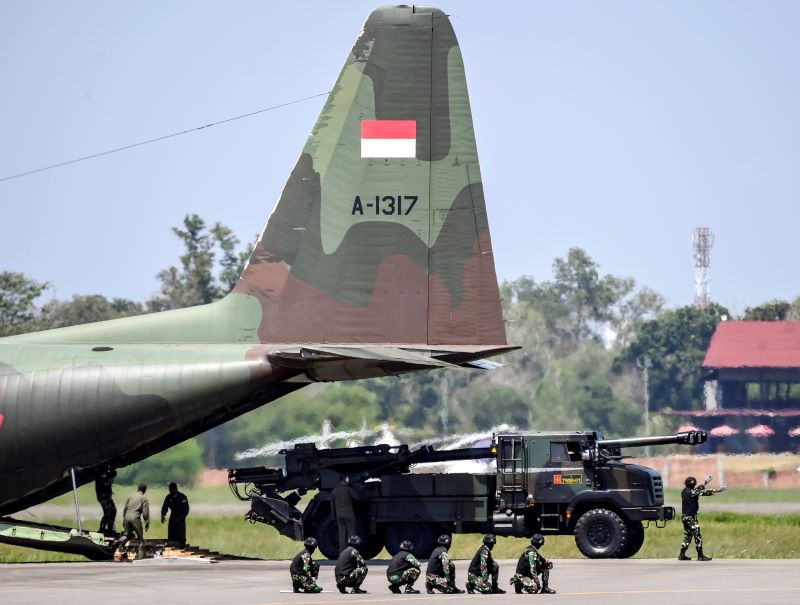 Kendaraan tempur Howitzer Caesar TNI AD berjalan keluar dari pesawat Hercules C-130 TNI AU.