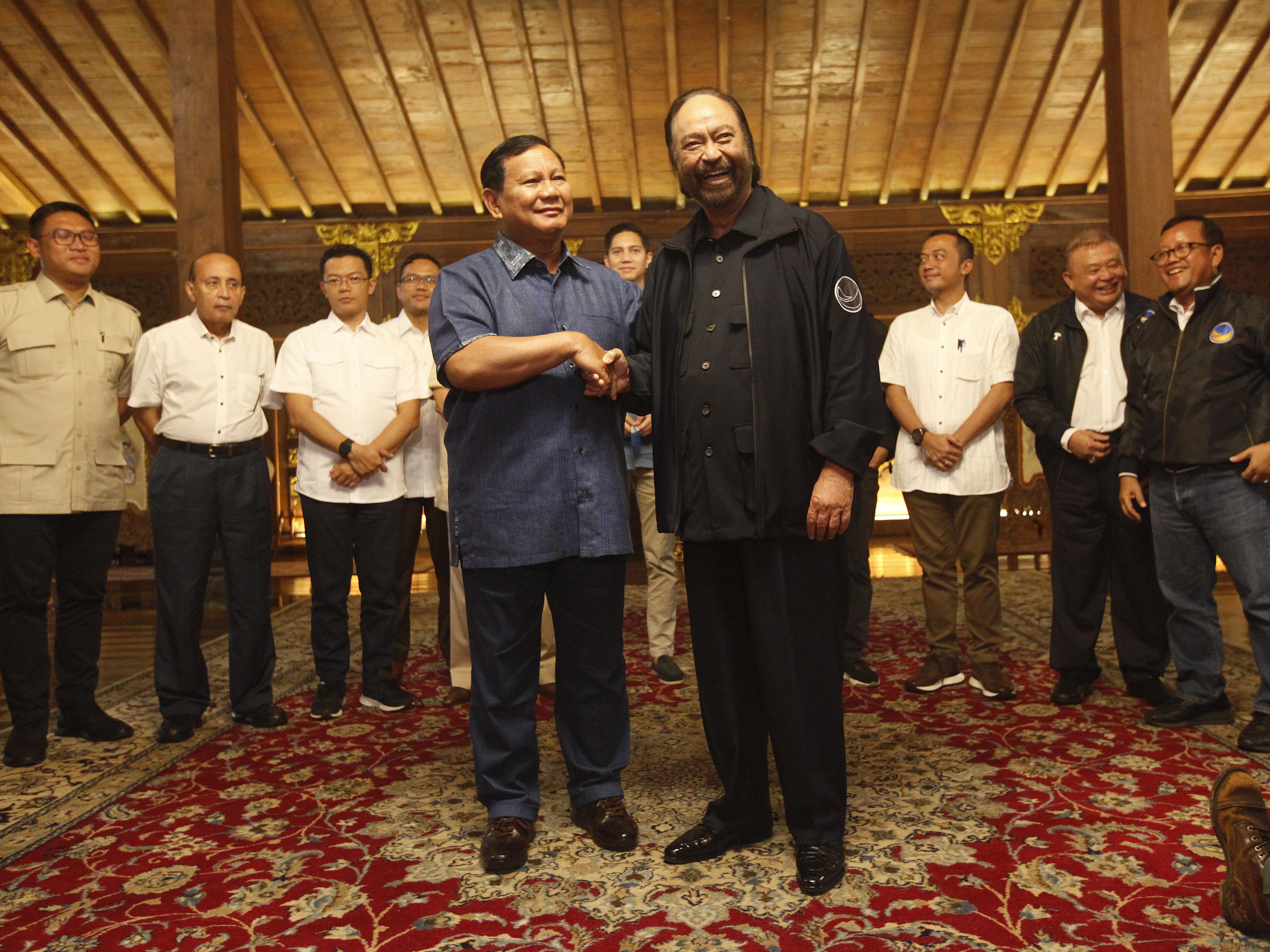 Ketua Umum Partai NasDem Surya Paloh bersama Ketua Umum Partai Gerindra Prabowo Subianto berjabat tangan usai berbicara kepada wartawan.