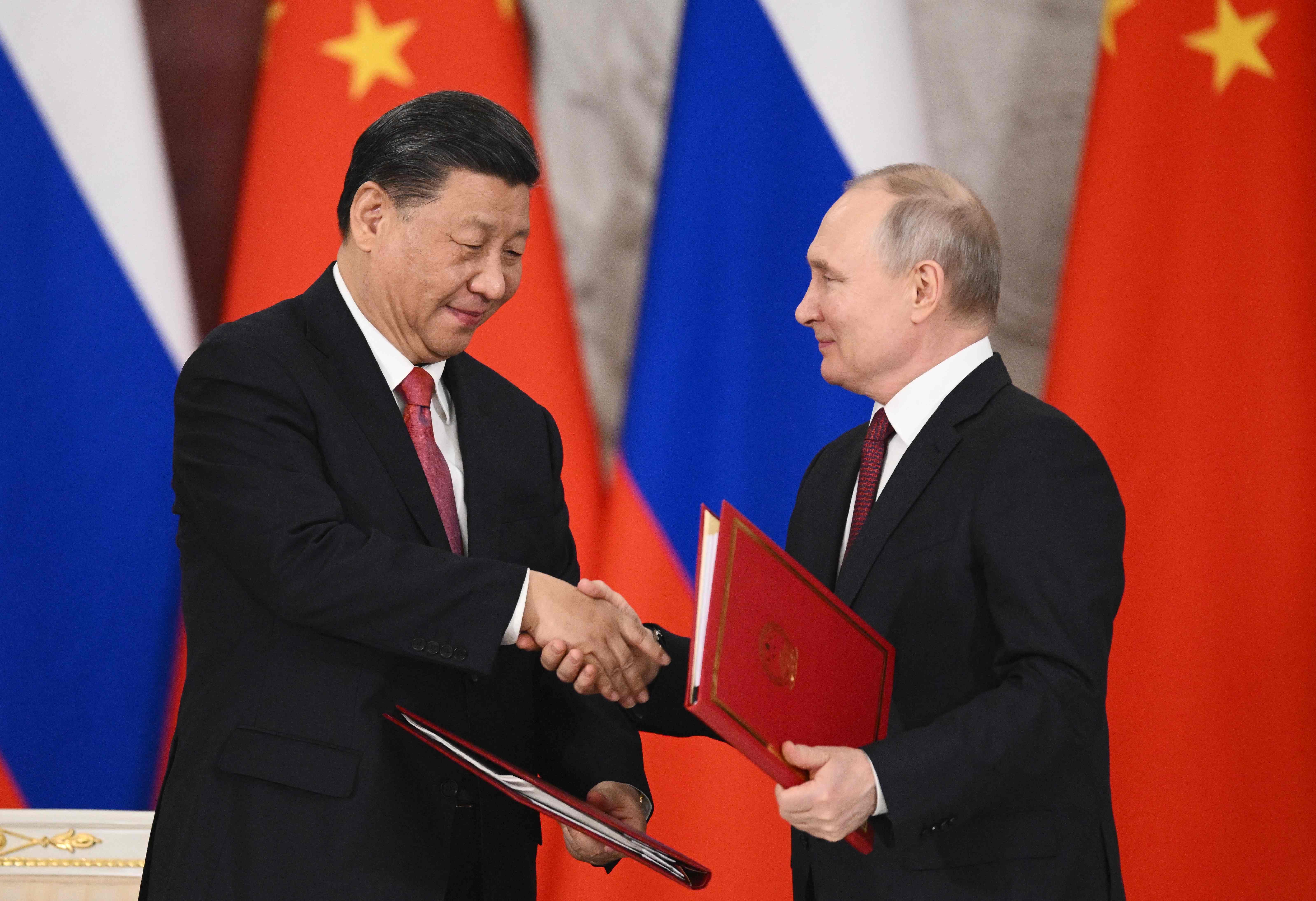 Presiden Rusia Vladimit Putin dan Presiden Tiongkok Xi Jinping berjabat tangan usai menandatangani kesepakatan di Kremlin, Moskow.