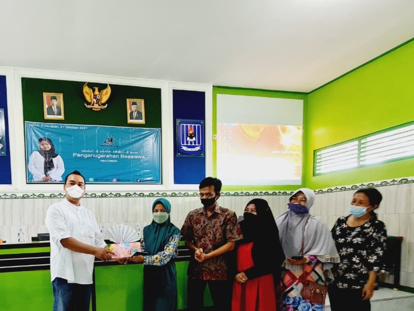 Didin Noor Ali (berbaju putih) tengah memberikan dana wakaf kepada para penerima).