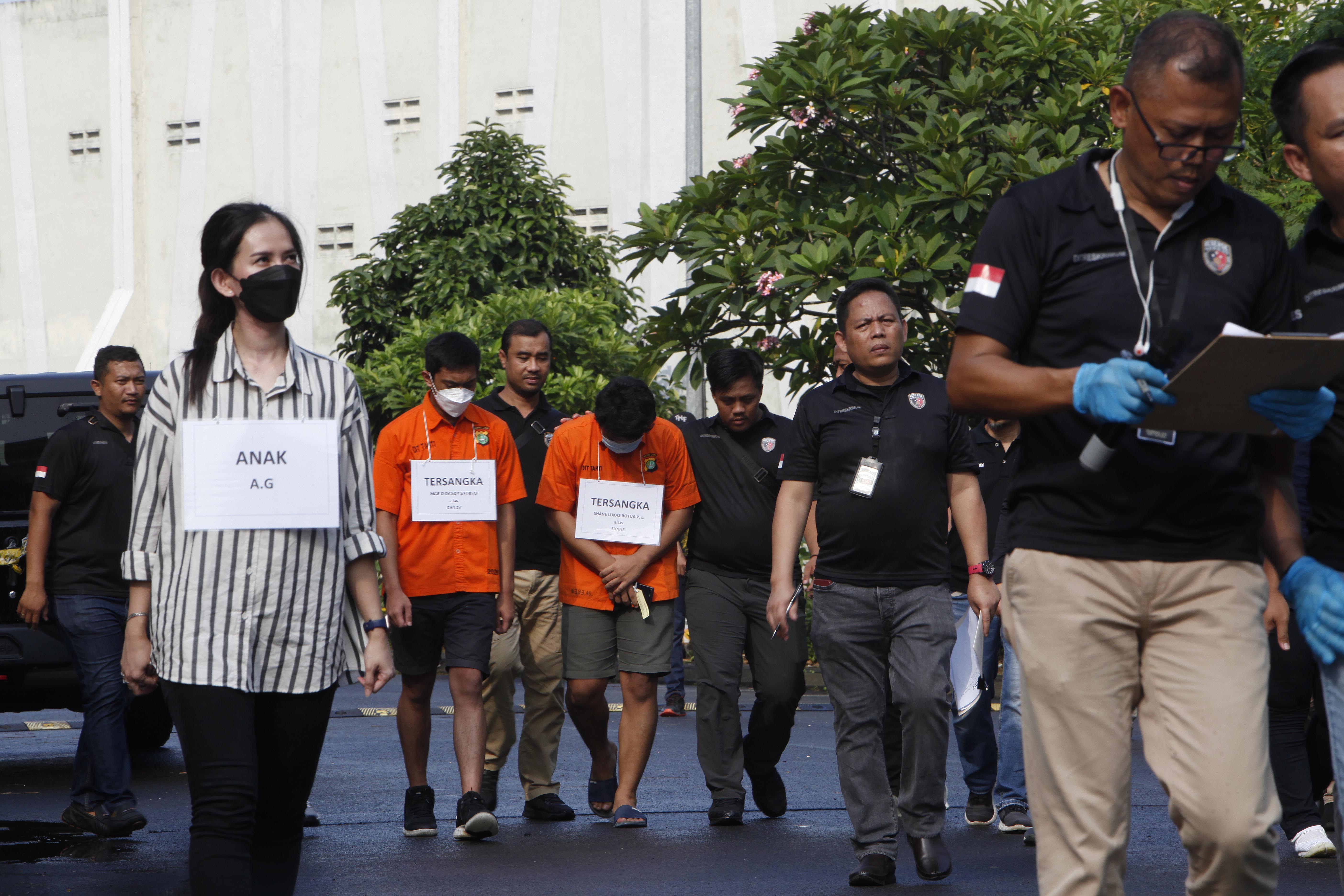 Tersangka Mario Dandy (tengah) dan Shane Lukas Rotua (kanan) dbersama anak AG yang diperagakan model melakukan reka ulang penganiayaan