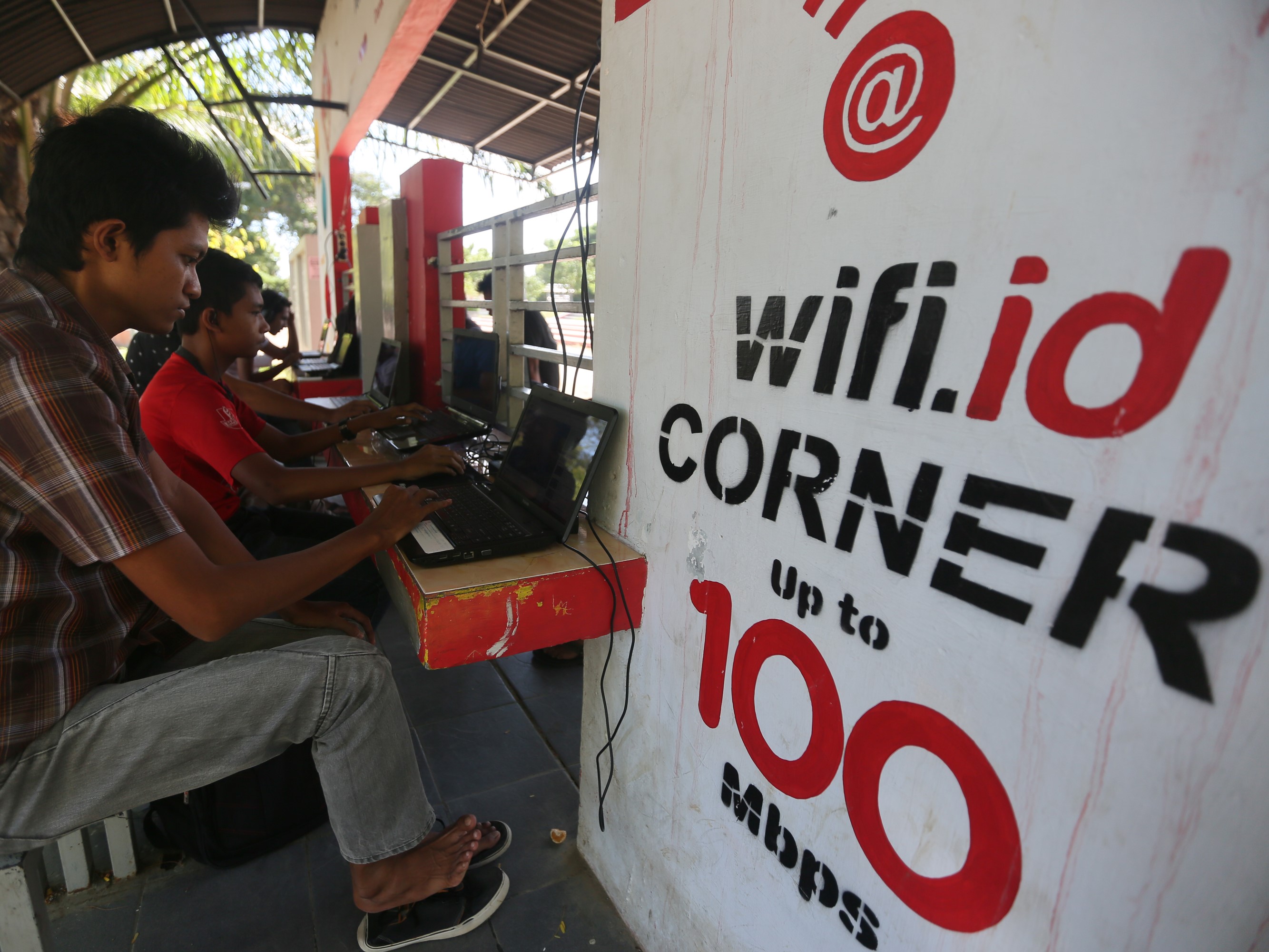 Warga mengakses internet dan bermain gim online dengan jaringan wifi yang disediakan pemerintah kota dan Telkom di Taman Sari, Banda Aceh.