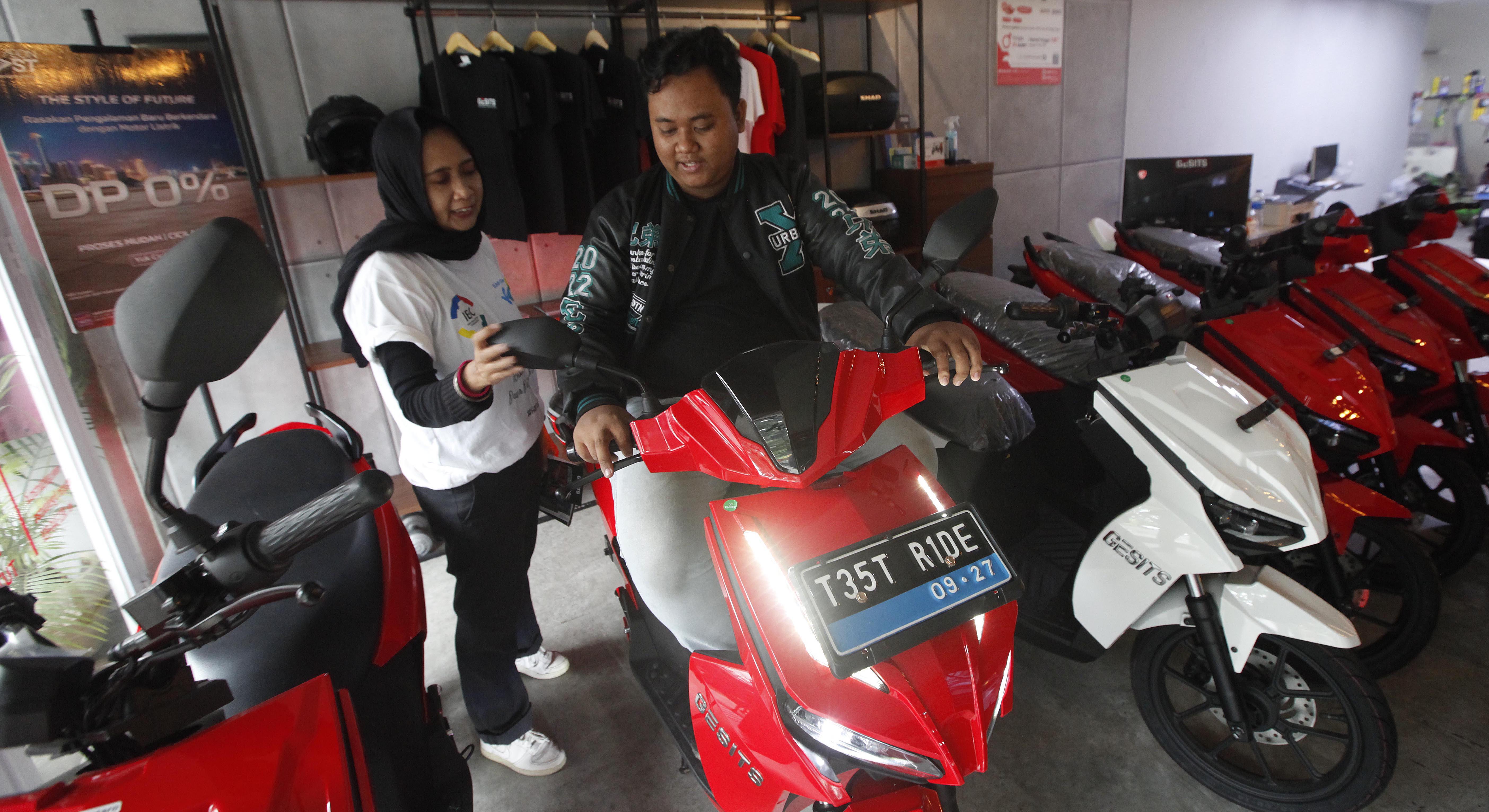 Tenaga penjual memberikan edukasi kepada calon pembeli terkait produk kendaraan listrik di diler motor listrik Gesits di kawasan Bintaro