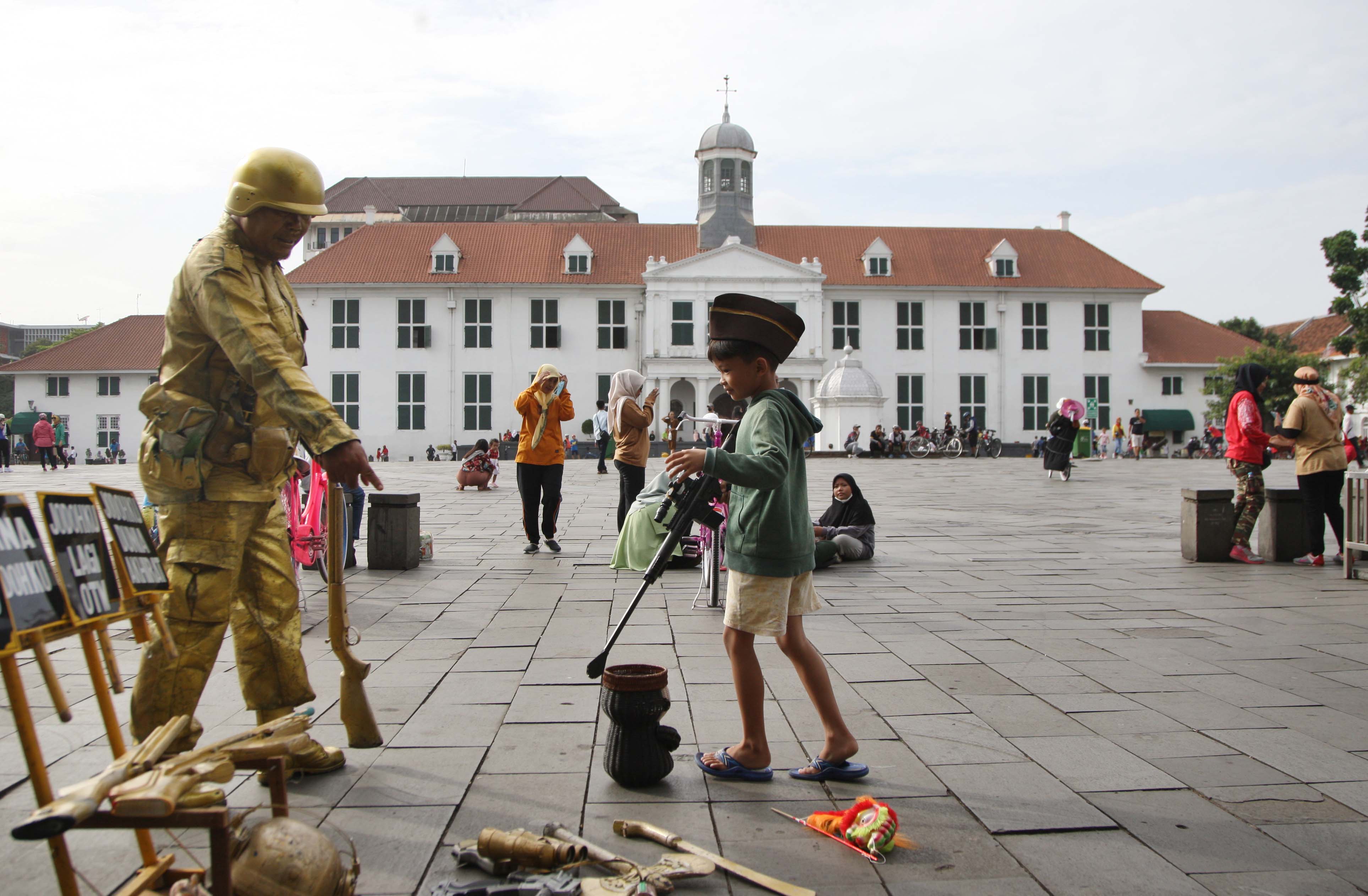 Pengunjung beraktivas menikmati suasana halaman Museum Fatahilah, kawasan Kota Tua, Jakarta
