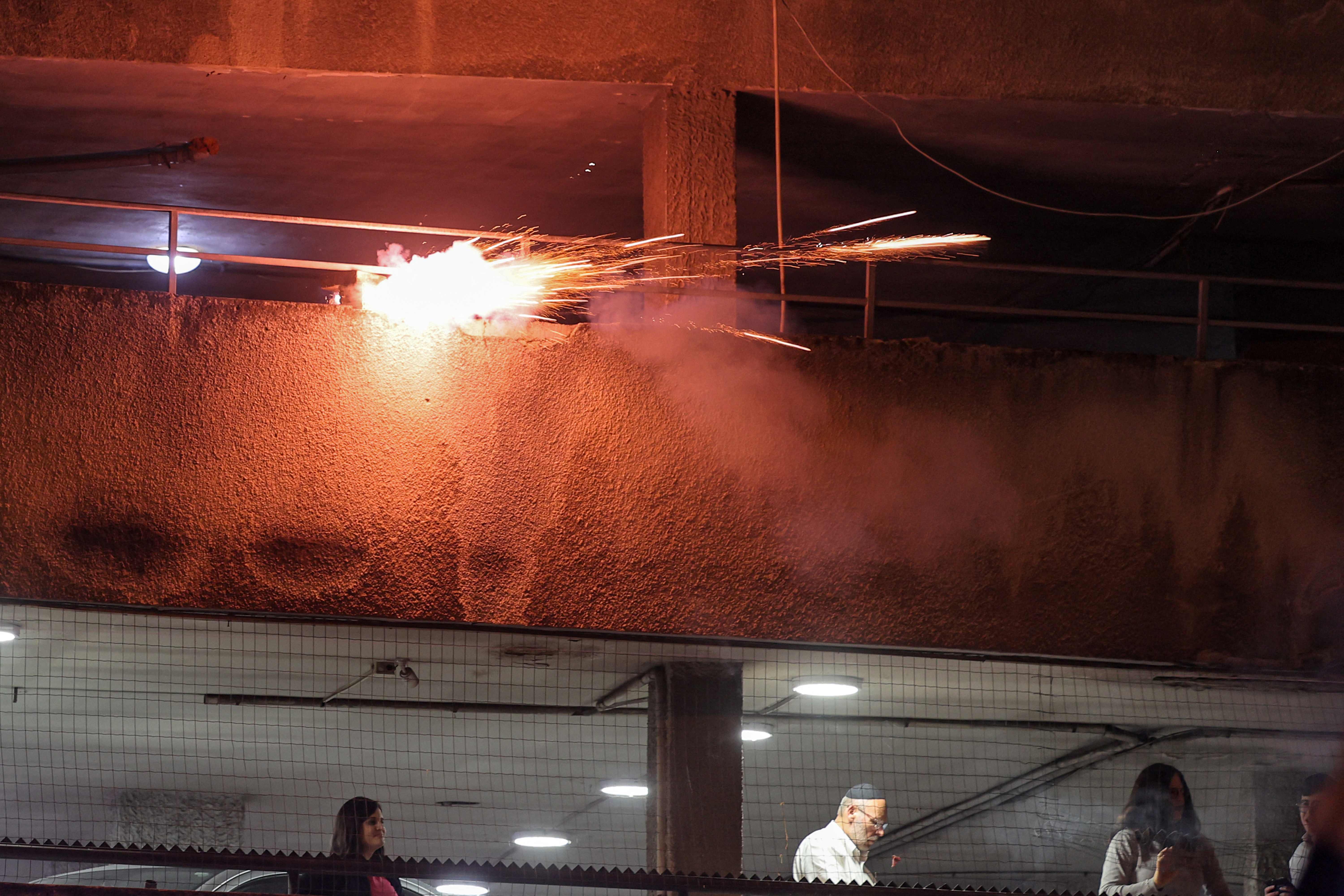 Kembang api ditembakkan dari sebuah gedung ke arah pengunjuk rasa menentang pemerintah Israel, Kamis (23/3/2023)