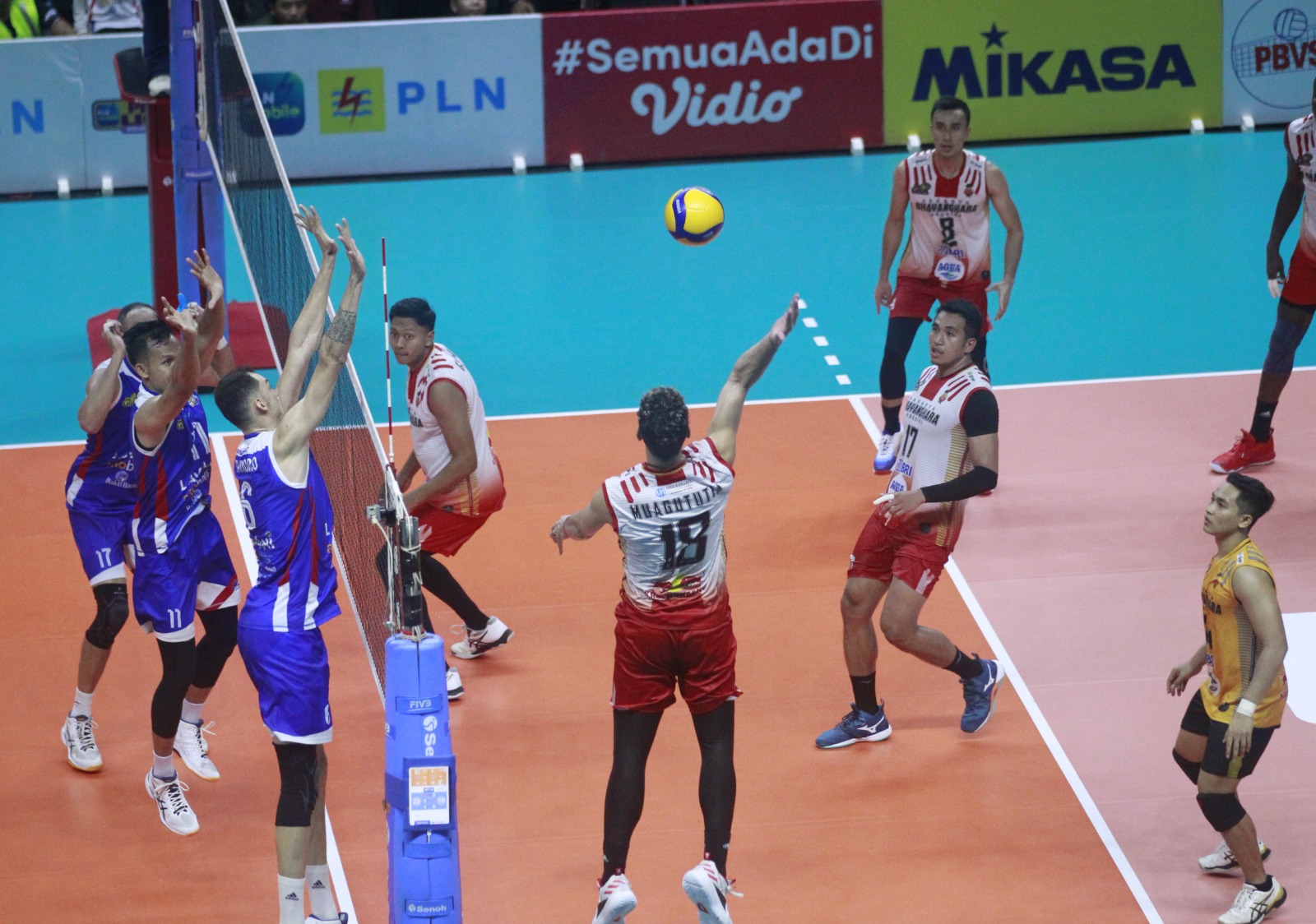 Pevoli Jakarta Bhayangkara Presisi Garrett Muagututia (tengah) hendak melakukan smash ke arah para pemain Jakarta Lavani Allo Bank.
