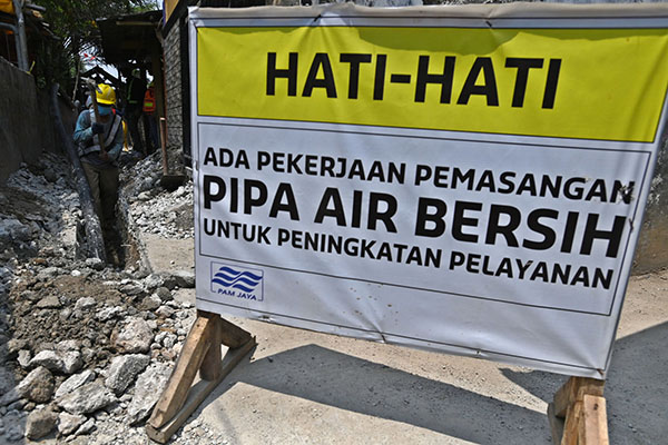  Pekerja Perusahaan Air Minum (PAM) Jaya menggali tanah untuk jaringan pipa air bersih di Kawal Muara, Jakarta.