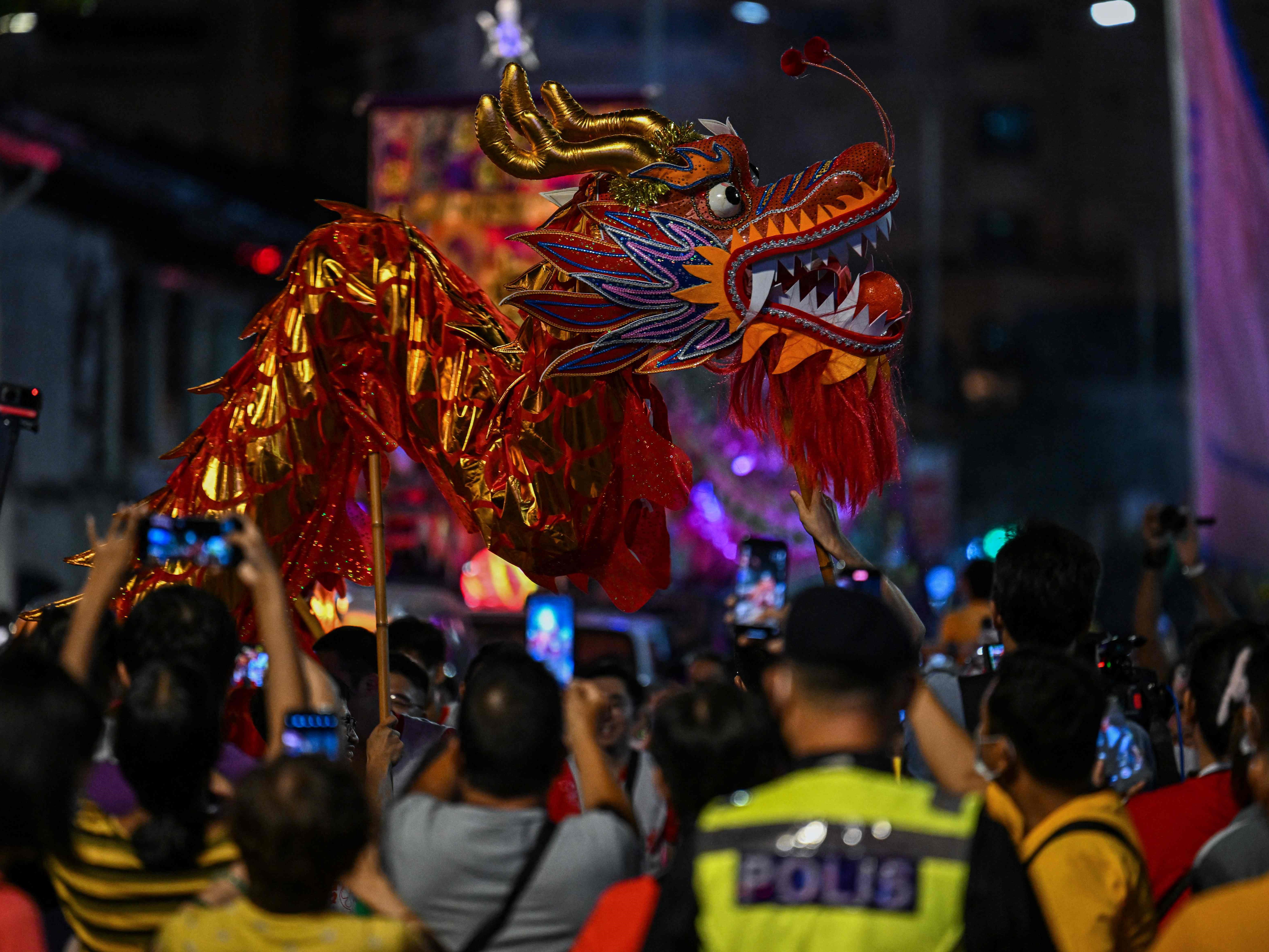 Penari tarian naga berjalan selama Pawai Chingay di Malaysia.