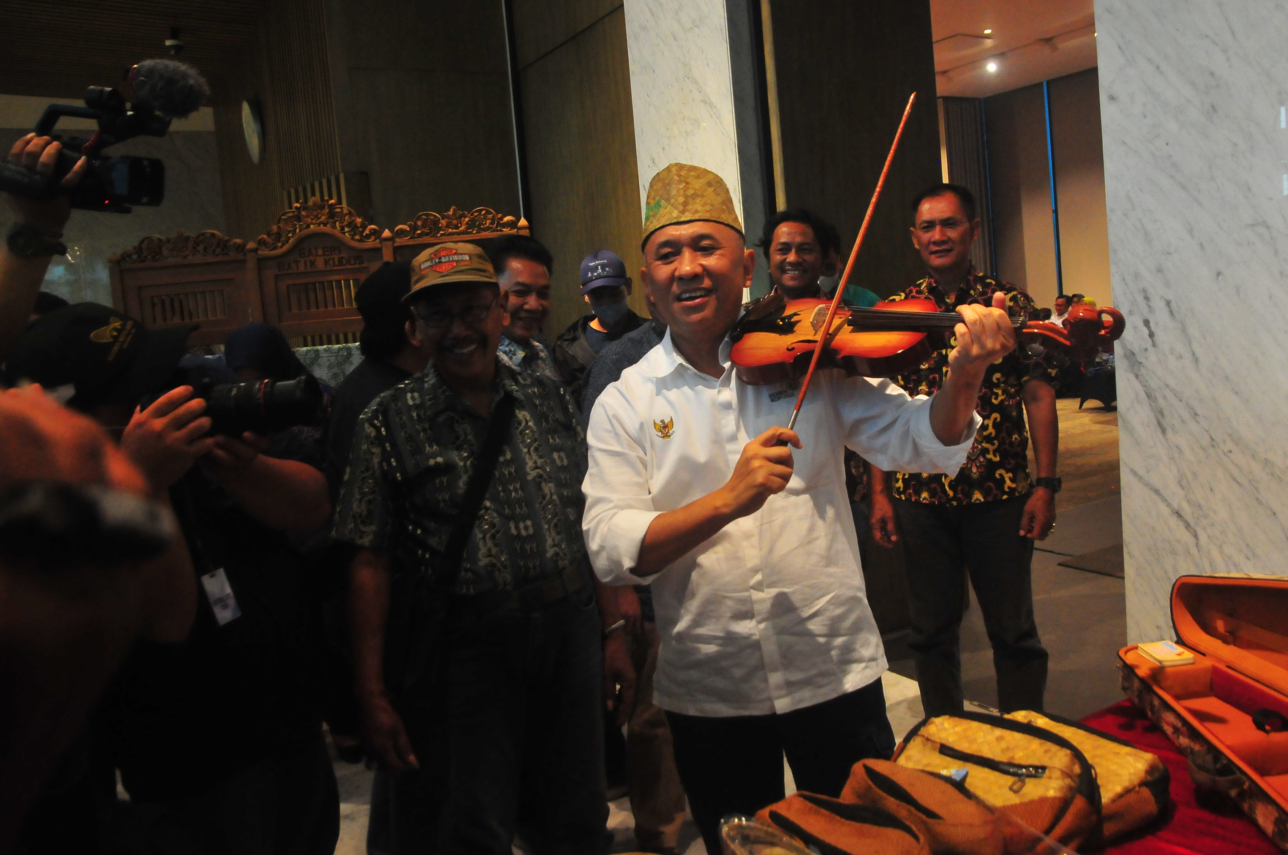 Menteri Koperasi dan UKM Teten Masduki (tengah) mengetes alat musik biola produksi salah satu Badan Usaha Milik Desa (BUMdes).