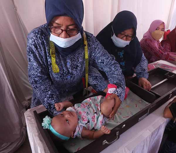 Petugas kesehatan mengukur tinggi bayi di Posyandu Mayang, Kelurahan Mrican, Kota Kediri, Jawa Timur.