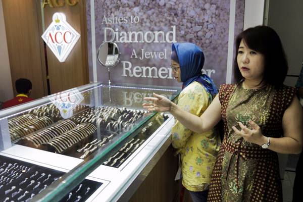 Pembeli tengah memilih emas di konter perhiasan.