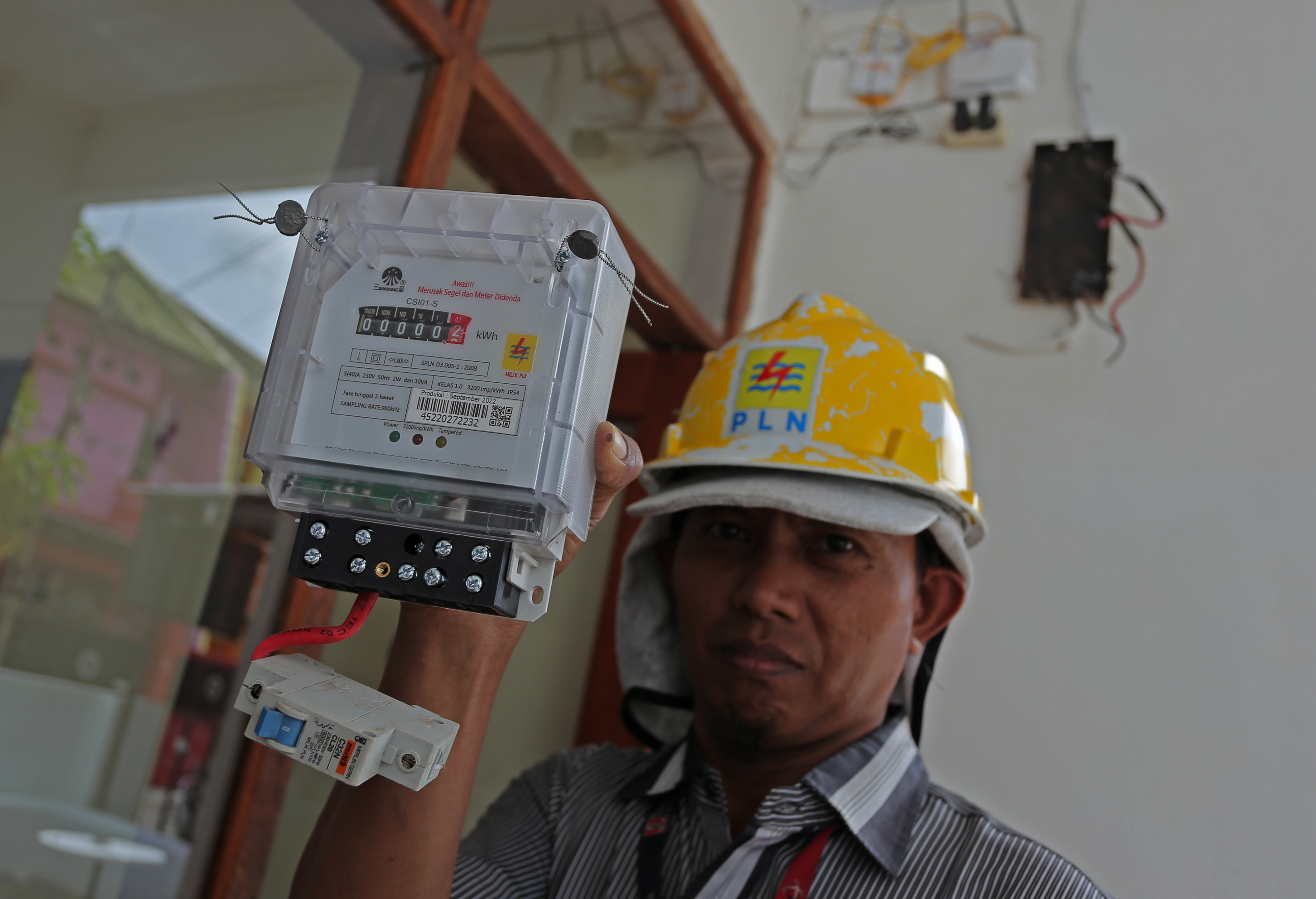 Teknisi memperlihatkan meteran listrik baru milik pelanggan di Makassar, Sulawesi Selata.