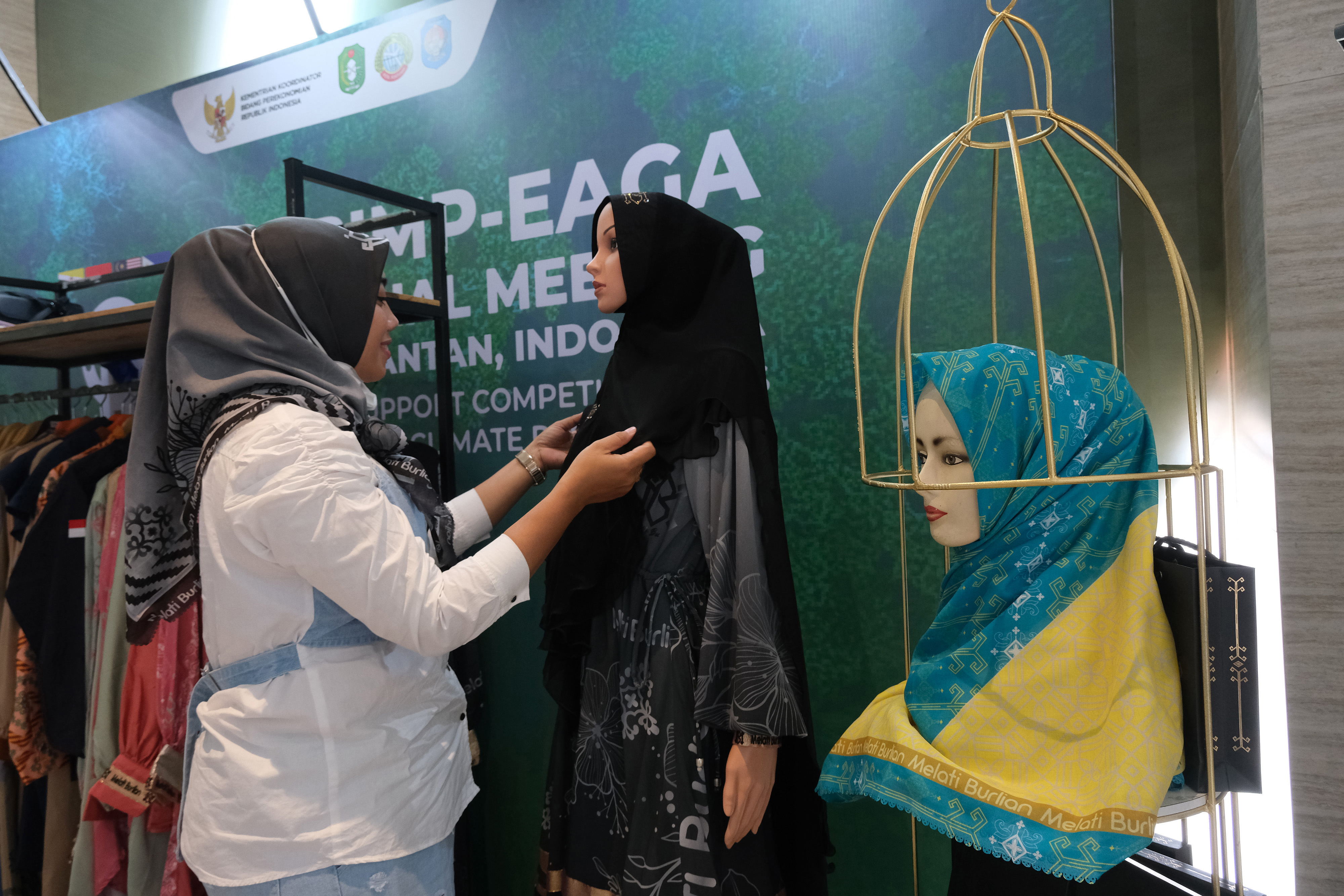 Desainer asal Kalimantan Barat Melati Burlian memajang busana dan hijab rancangannya di stand sebuah pameran.