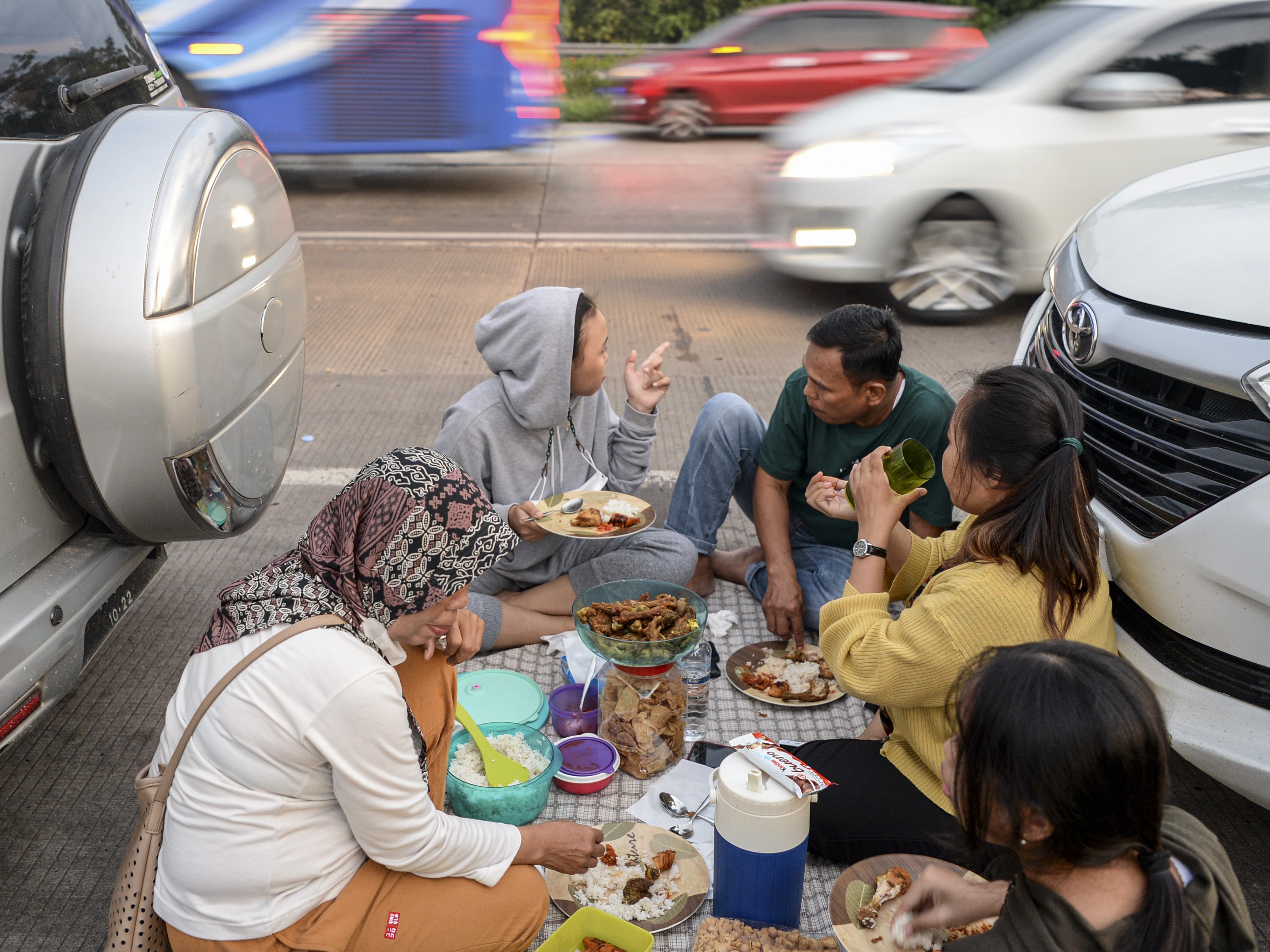 Sejumlah pemudik menyantap hidangan buka puasa bersama di pinggir ruas jalan Tol Cikopo-Palimanan, Purwakarta, Jawa Barat.