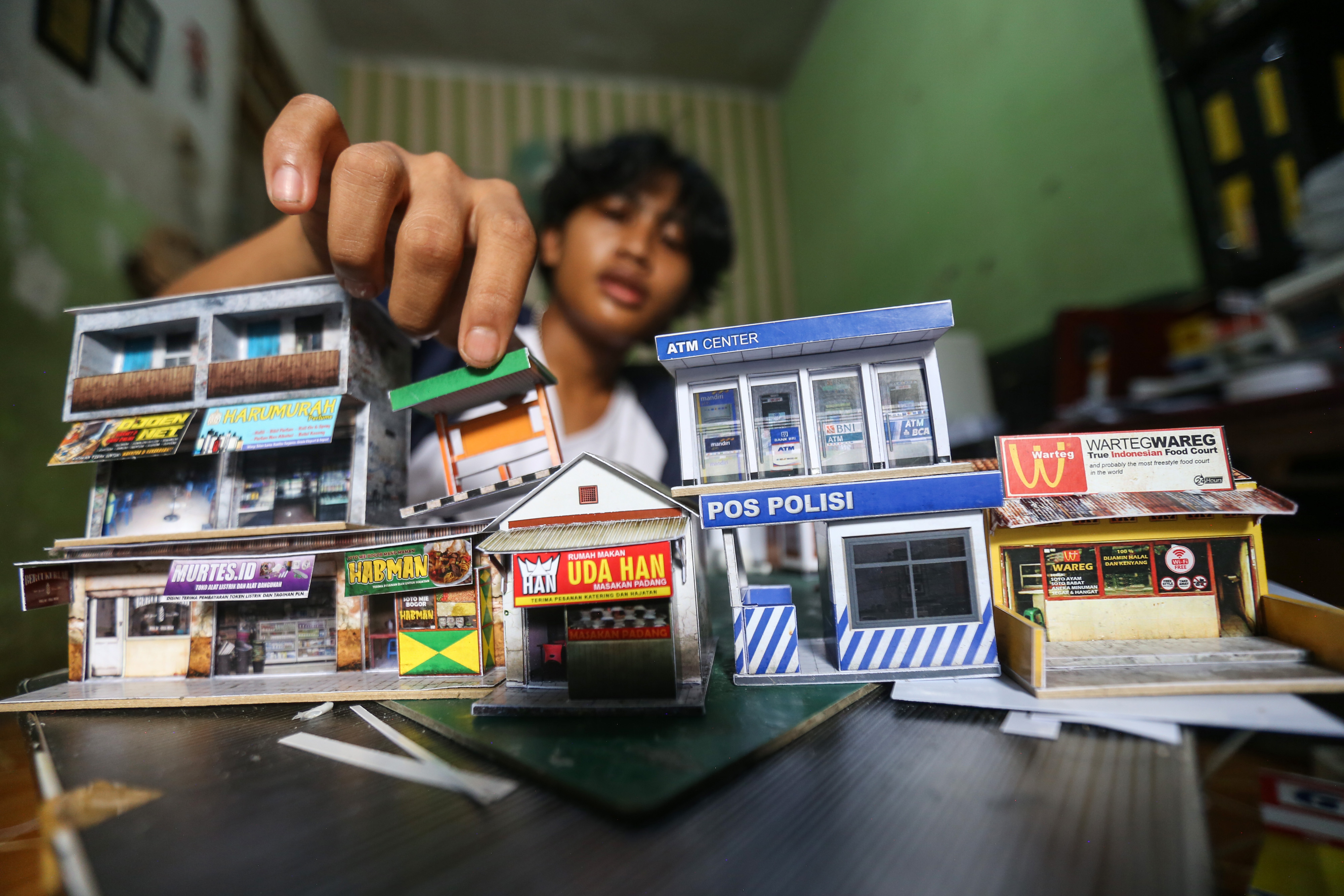 Ilustrasi--Perajin menata miniatur pertokoan di rumah produksi Craftoys 181, Depok, Jawa Barat