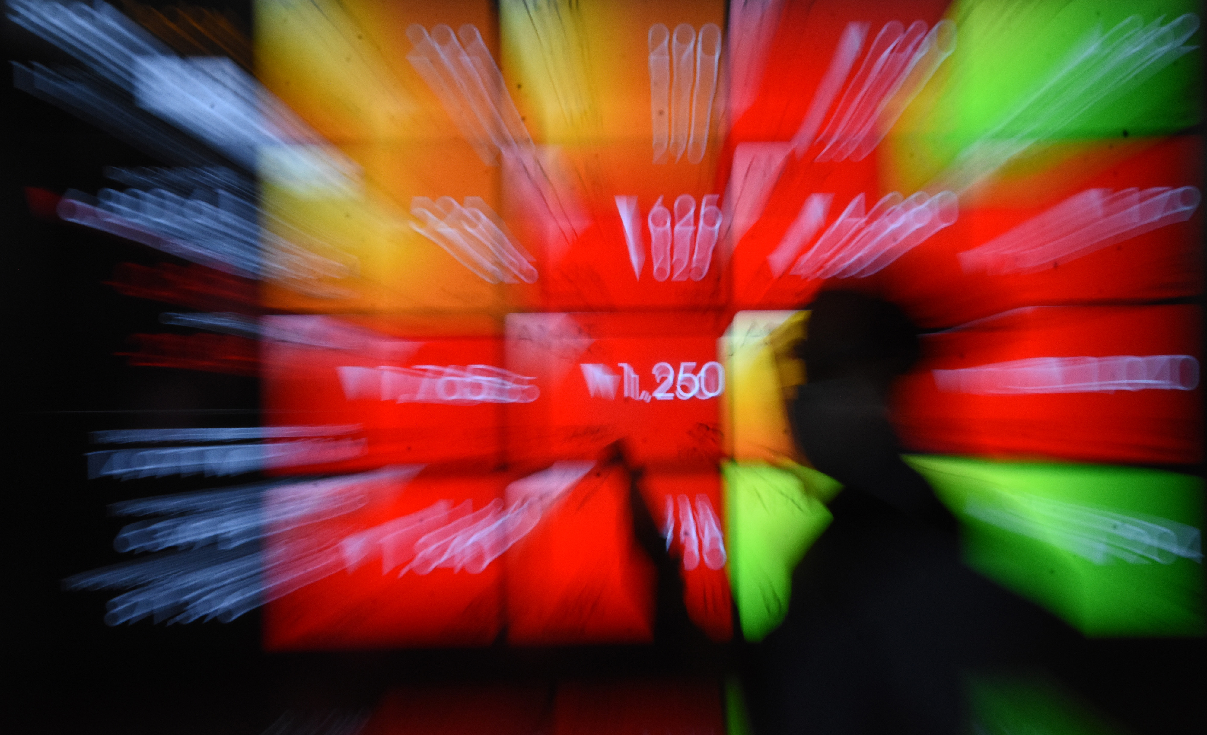  Pekerja melintas di depan layar indeks harga saham di Bursa Efek Indonesia, Jakarta, Jumat (11/2/2022).