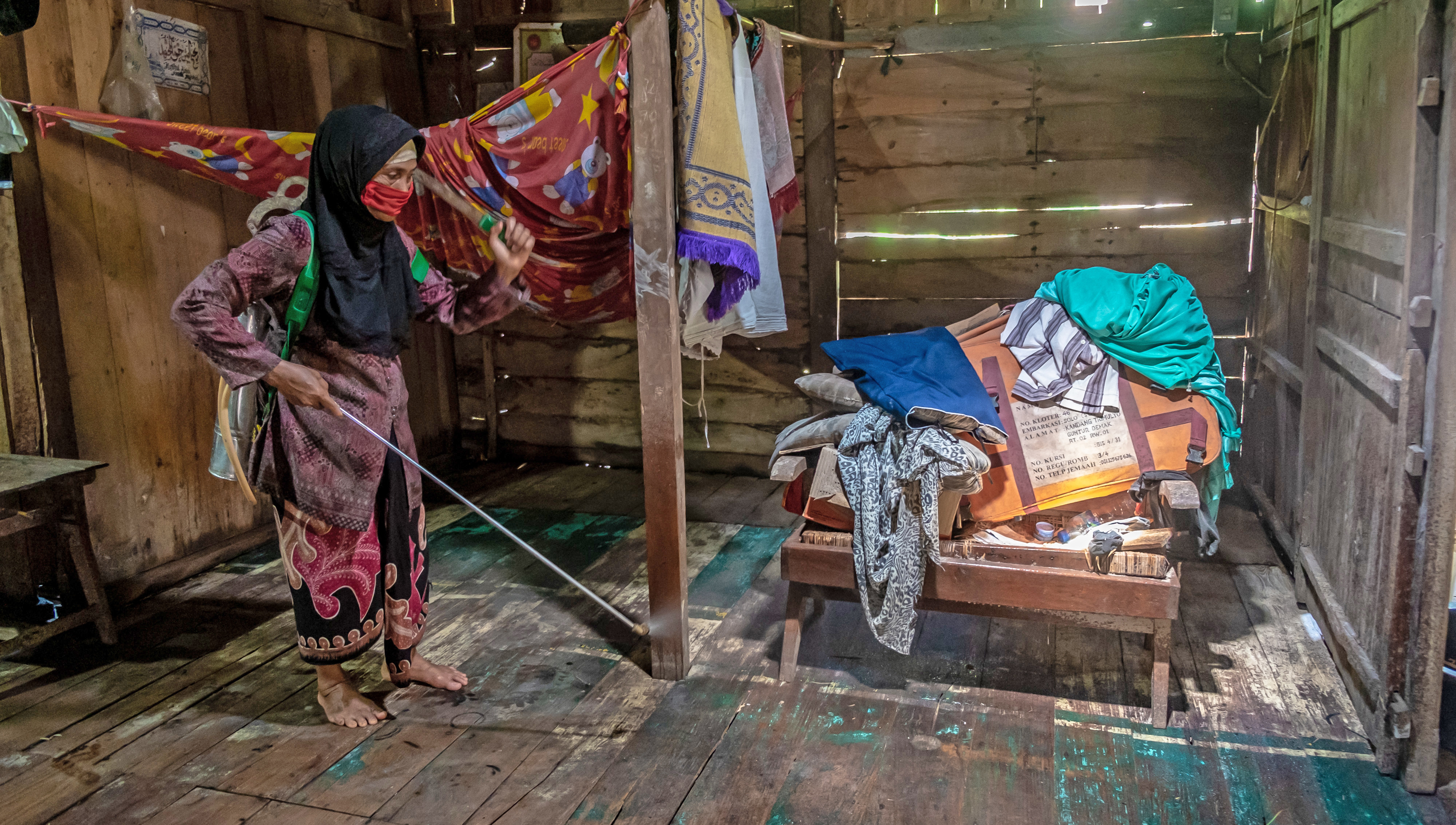 Seorang warga menyemprot cairan kaporit di dalam rumahnya yang terdampak banjir untuk pencegahan penyakit Leptospirosis