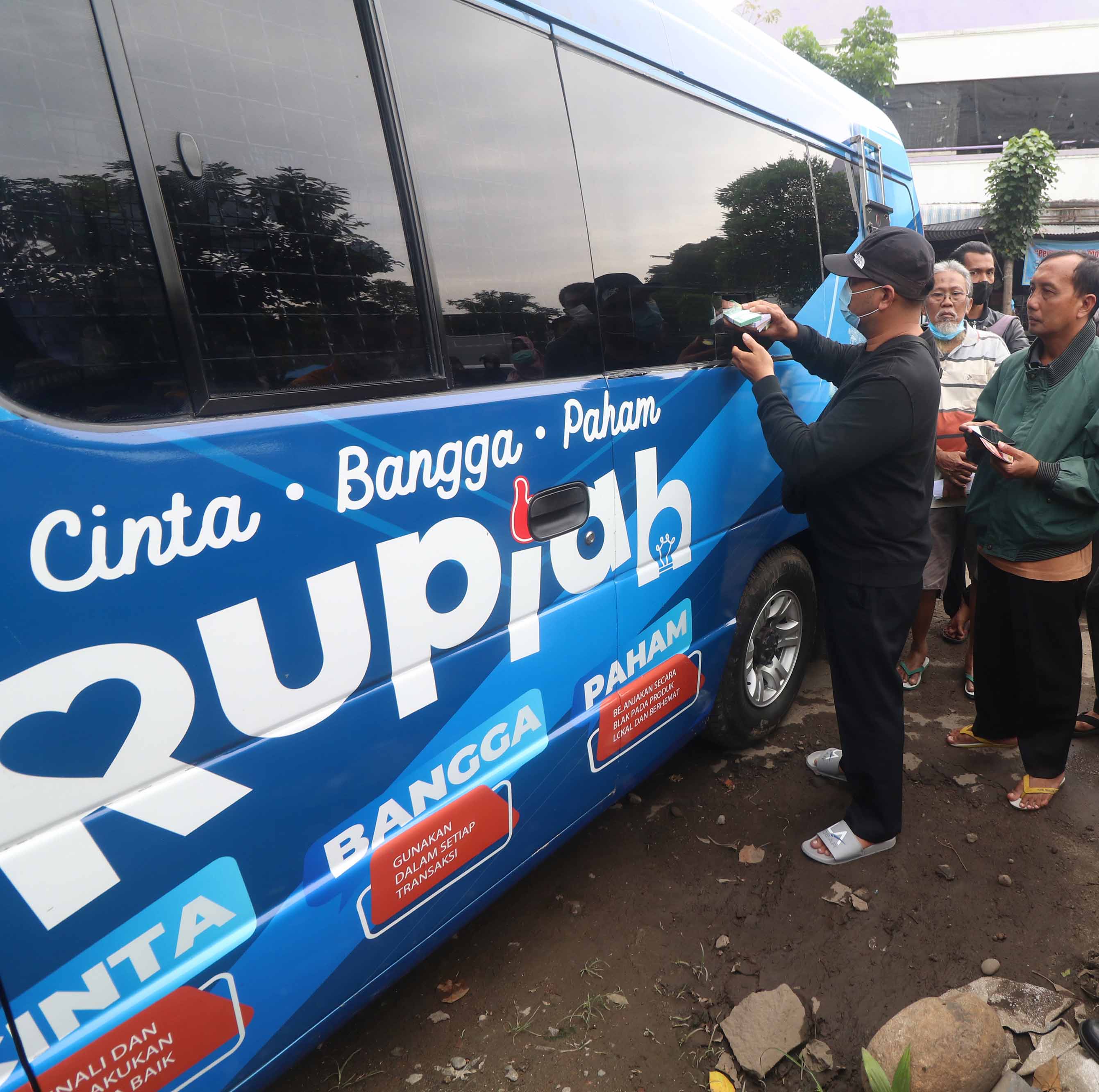 Warga antre menukarkan uang baru pada mobil kas keliling Bank Indonesia di pasar tradisional Bandar, Kota Kediri, Selasa (28/2/2023)