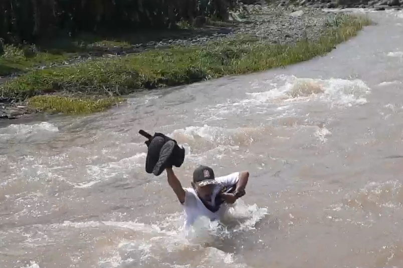 Warga nekat melewati sungai akibat jembatan hanyut.