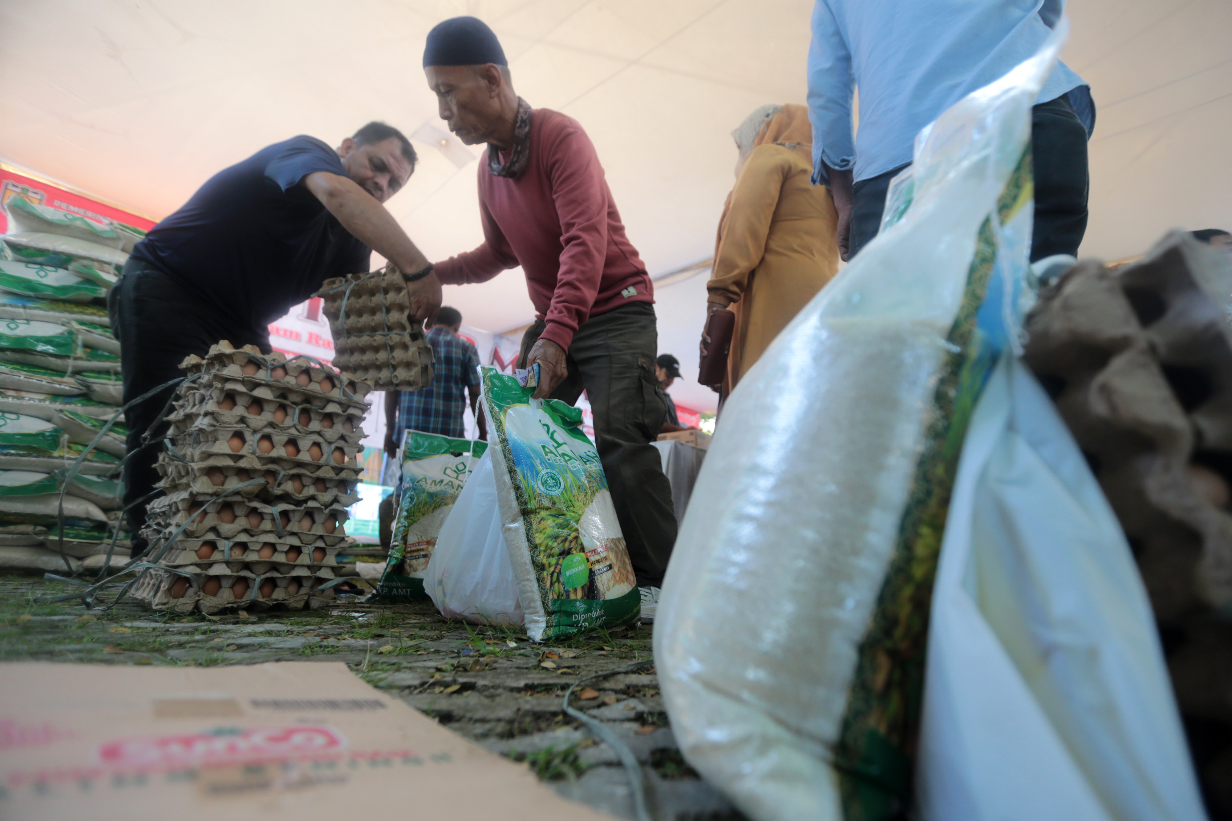 Seorang warga mengambil paket sembako.