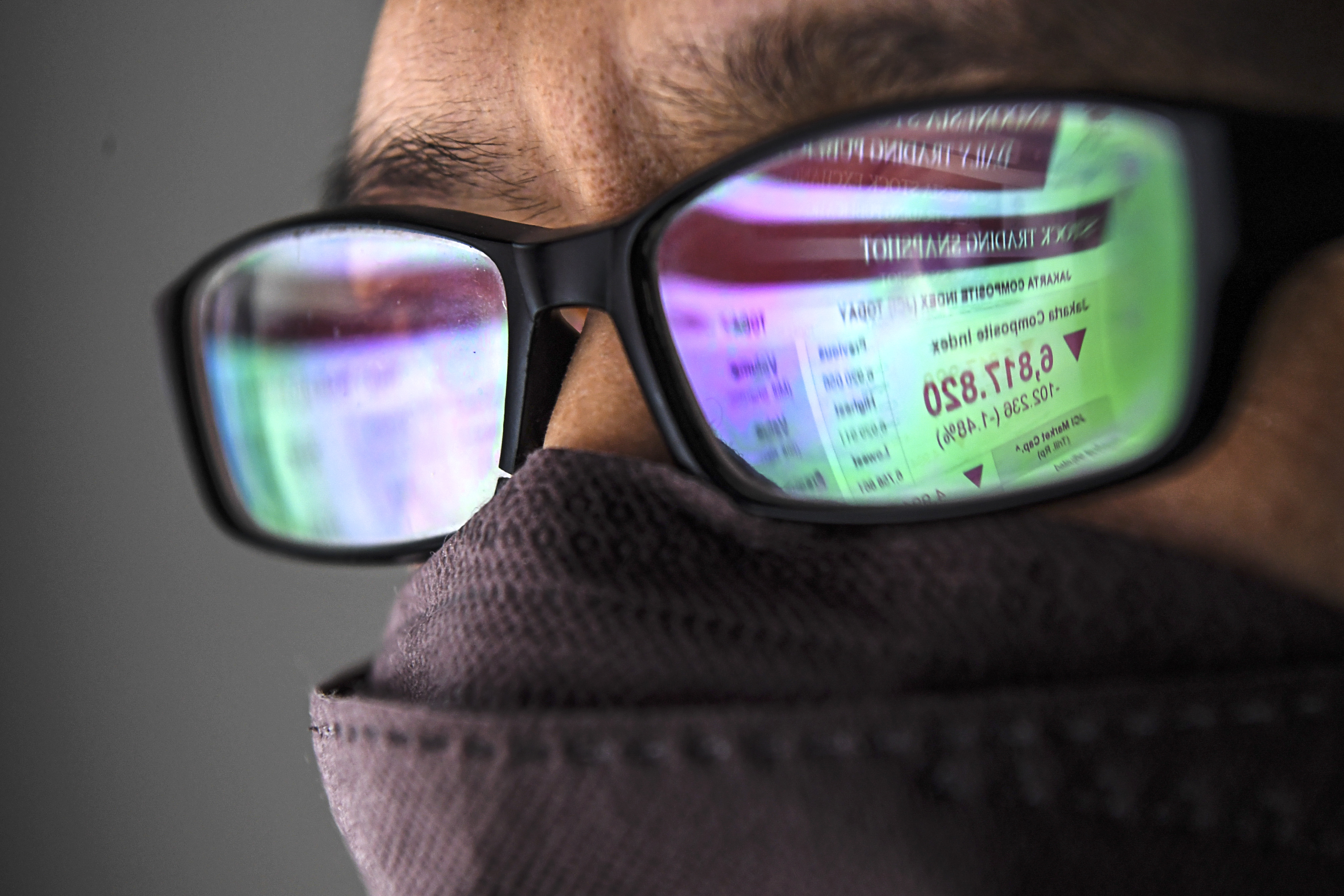 Warga melihat layar pergerakan saham di Jakarta, Kamis (24/2/2022). 