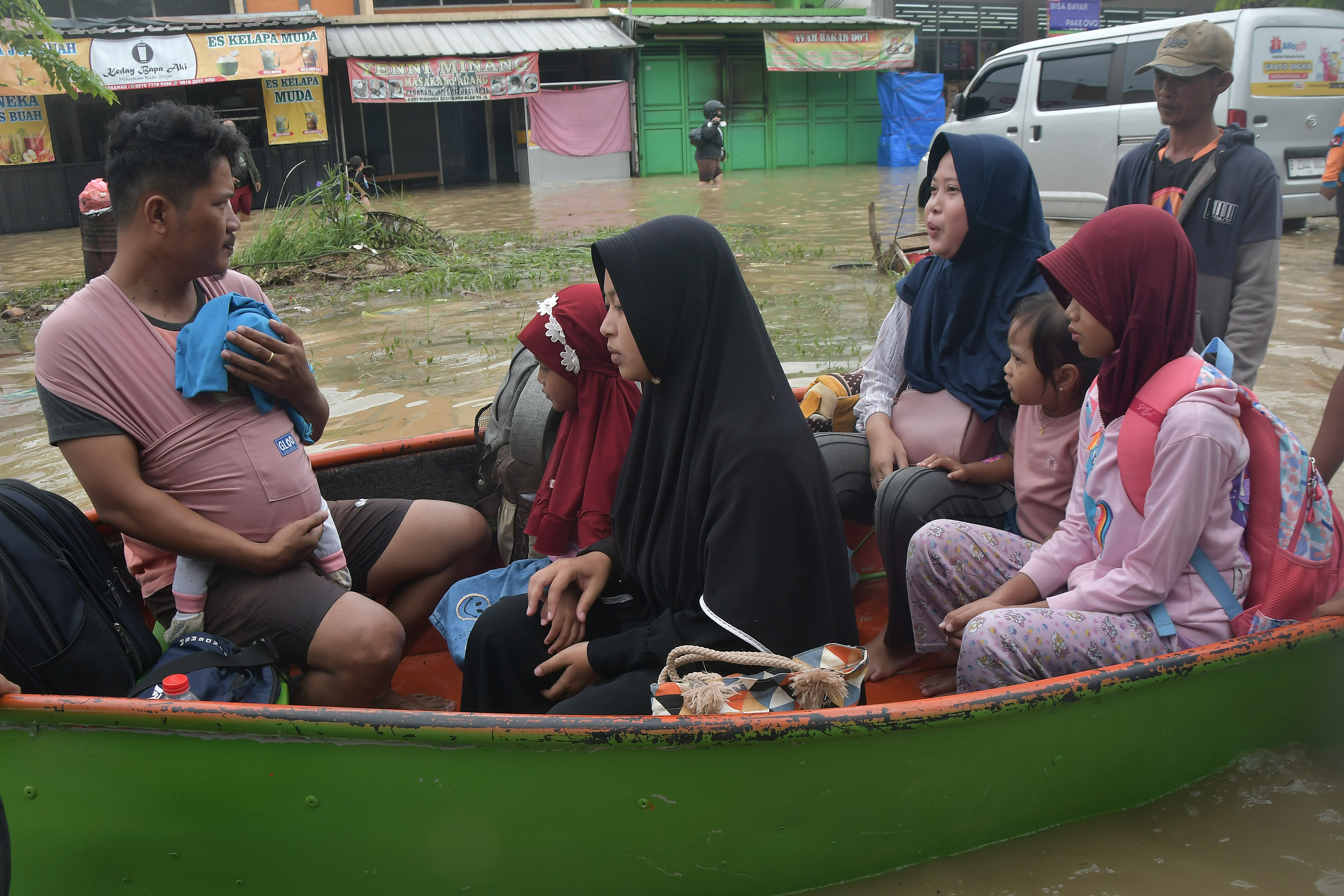 Warga menggunakan perahu saat banjir di Karang Bahagia Cikarang Utara, Kabupaten Bekasi, Jawa Barat, Sabtu (25/2).