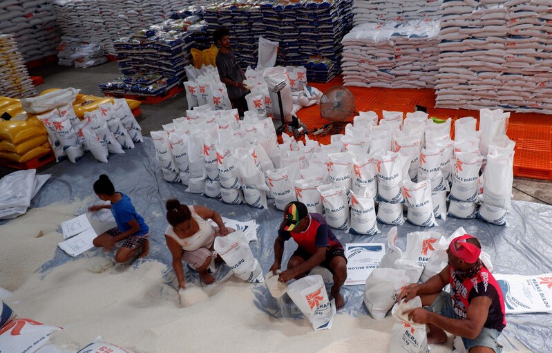 Pekerja mengemas beras impor Vietnam ke dalam karung di Gudang Bulog Argapura, Distrik Jayapura Selatan