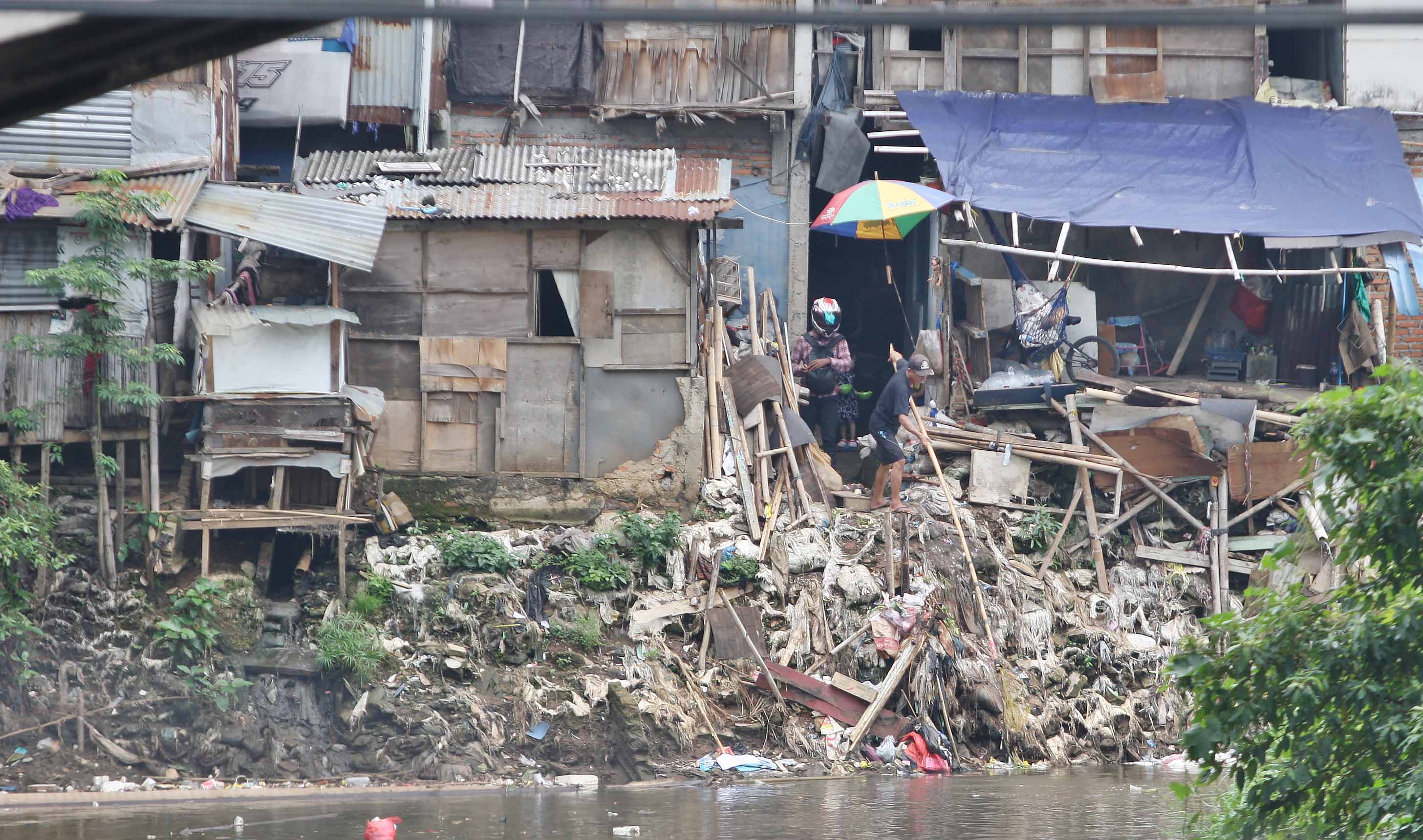 Ilustrasi--Warga beraktivitas di pemukiman kumuh bantaran Kali Ciliwung di Kelurahan Kebon Manggis, Matraman.